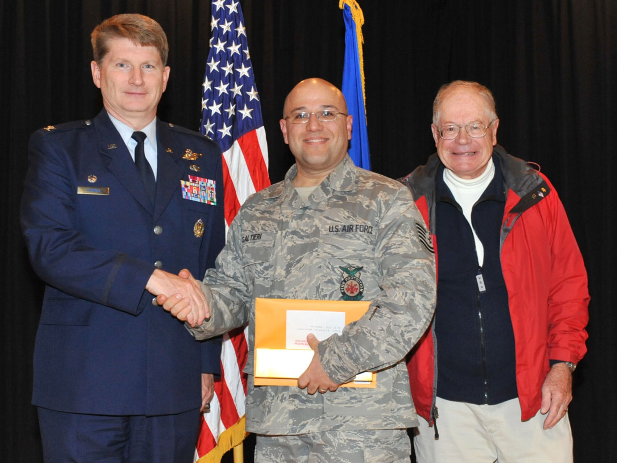 FAIRCHILD AIR FORCE BASE, Wash. – Col Robert Thomas, 92 Air Refueling Wing commander, Mr. Graham Crutchfield, a retired Marine, and Tech. Sgt. Richard Galtieri, 92 Civil Engineer Squadron fire fighter, pose for a photo after he received the commemorative knife Oct. 13. (U.S. Air Force photo / Staff Sgt. JT May III)
