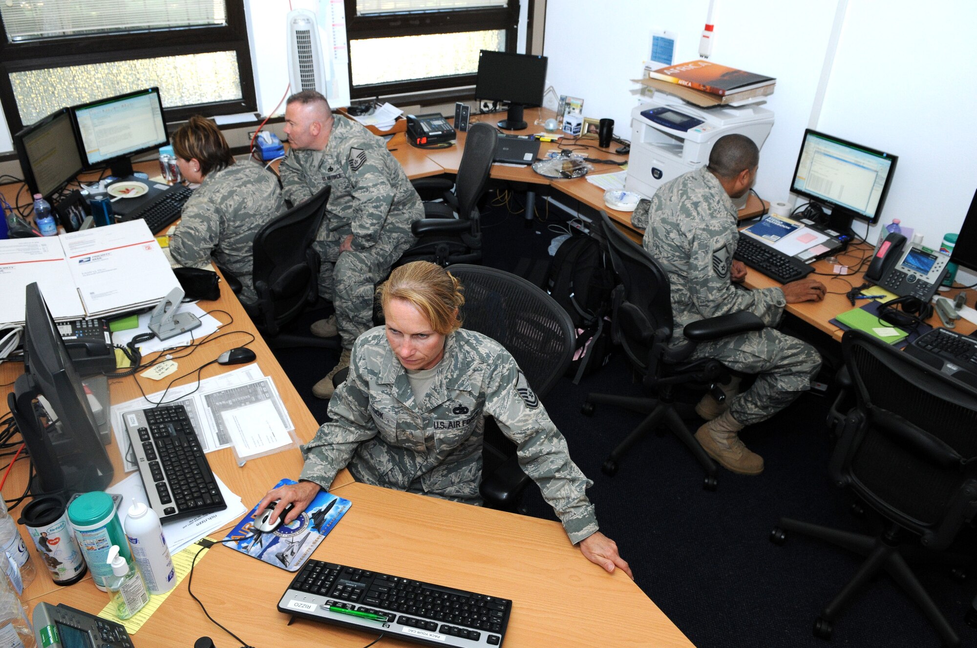 RAMSTEIN AIR BASE, Germany -- (Clockwise from right) Master Sgt. Shaun Ford, Master Sgt. Susan Cook, Capt. Amanda Sater and Master Sgt. Rich Rizzo of 17th Air Force's A4/7 (Logistics) Directorate share a small work space due to ongoing construction and the growing size of the staff. Ten workstations have been improvised in the 248-square foot room. (USAFE photo by Master Sgt. Jim Fisher)  