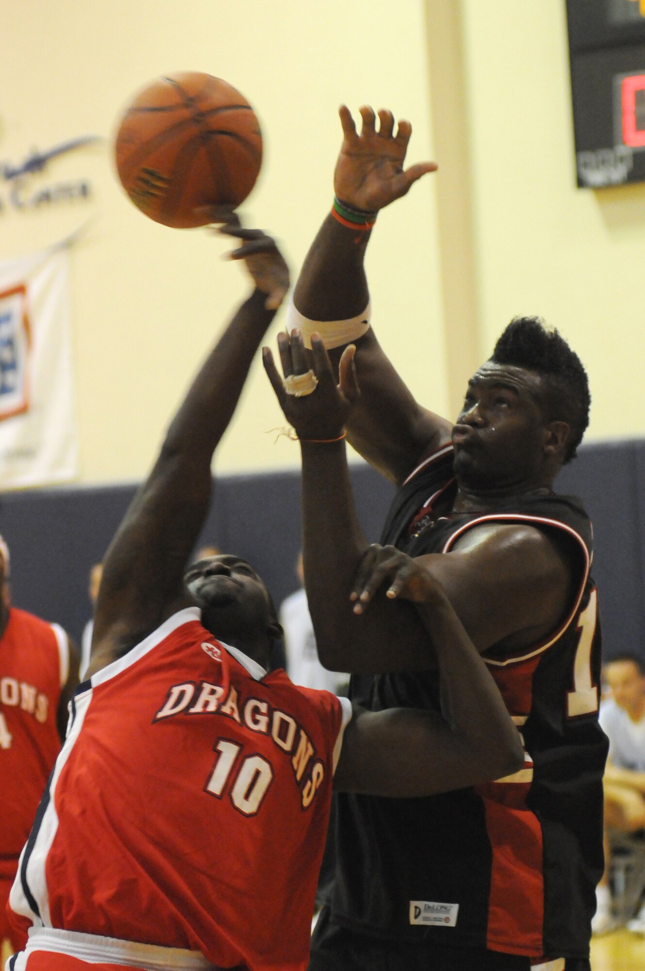 Leathon Magee, Aviano varsity basketball team member, tussles with Justice, from the television show "American Gladiators", for the ball during a basketball game against the Hollywood Knights Oct. 20, 2009 at the Dragon Fitness Center on Aviano Air Base, Italy. The Hollywood Knights celebrity basketball team competed in a game against the 31st Fighter Wing leadership and members of the base's varsity basketball team as part of a USO Tour. The home team beat the Hollywood Nights 82-76. The celebrities signed autographs and took photos with fans during halftime and after the game. The Hollywood Knights consists of television, motion picture and musical recording stars. (U.S. Air Force photo/ Staff Sgt. Patrick Dixon)