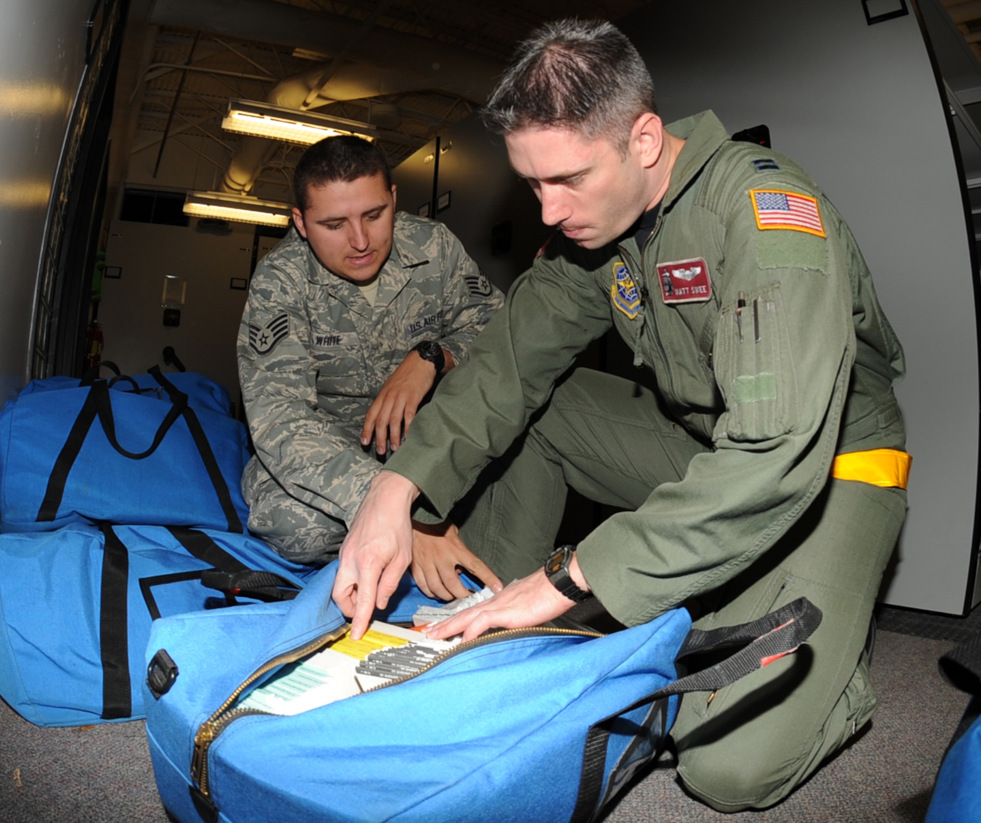 Staff Sgt. Rodney White, 22nd Operation Support Squadron a combat crew communicator, and Capt. Matthew Swee, a KC-135 Stratotanker pilot from the 384th Air Refueling Squadron, inspect a flight information publication bag, Oct. 15, 2009, at McConnell Air Force Base, Kan., during a Nuclear Operational Readiness Inspection. The bags hold flight maps, books, charts and airport information that assist aircrews during flight. (U.S. Air Force Photo/Airman 1st Class Ruiz)