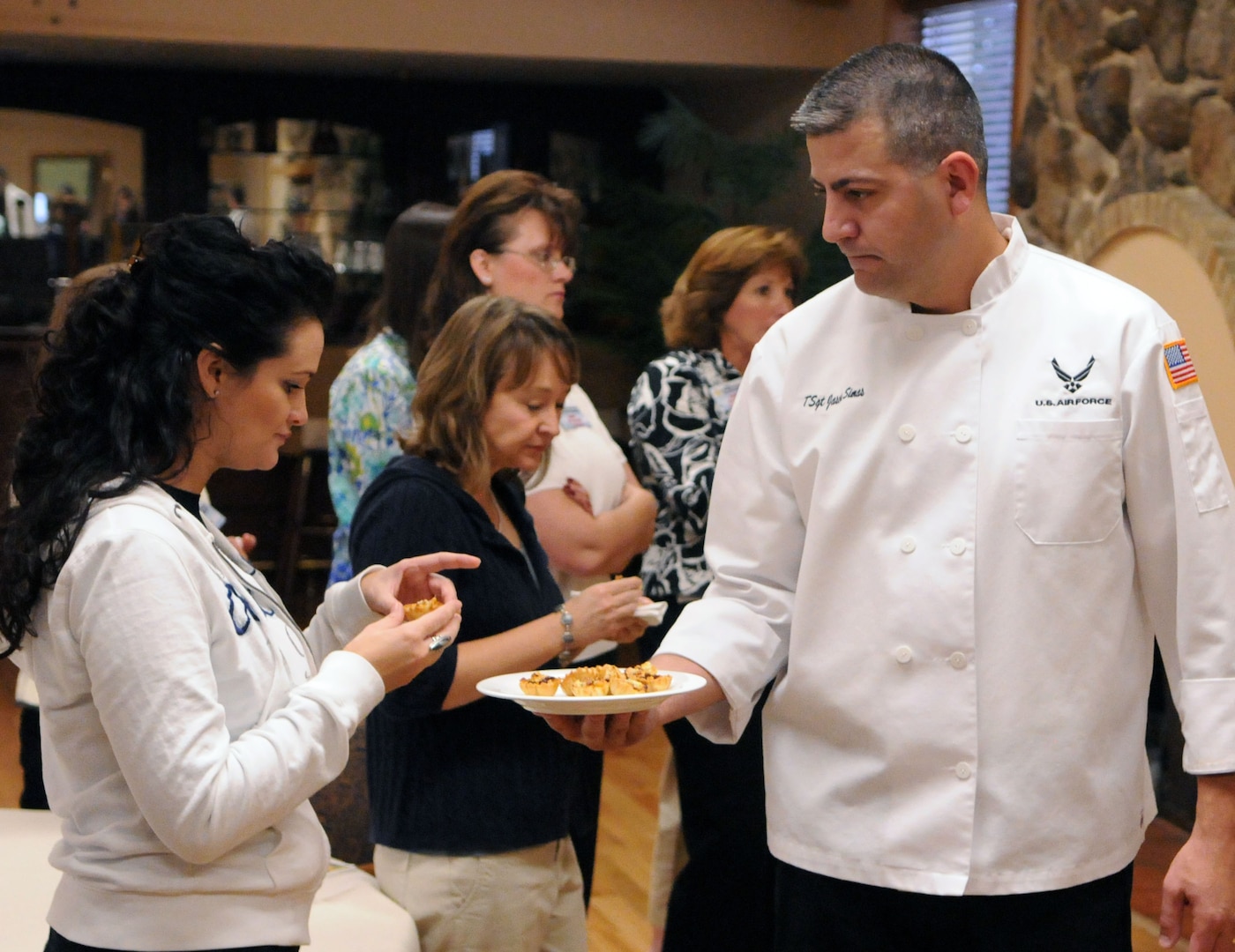 Tech. Sgt. Jason Simas, enlisted aide to the Air Education and Training Command vice commander, offers an appetizer to a spouse during the appetizer demonstration held at Randolph Air Force Base's Parr O' Club during the AETC Commander's, Command Chief's and Spouses' conference Oct. 19-23. (U.S. Air Force Photo By Don Lindsey)