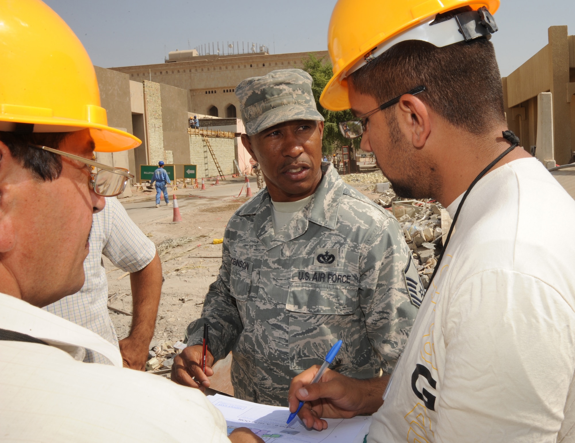 BAGHDAD -- Air Force Master Sgt. Tommy Robinson, joint area support group department of public works Team 2 noncommissioned officer in charge, coordinates with Iraqi contractors responsible for construction projects located in the International Zone Oct. 18, 2009. Sergeant Robinson is responsible for ensuring contractors follow contract agreements, safety rules and national electric codes. He is deployed from Luke Air Force Base, Ariz., and hails from Graceville, Fla.  (U.S. Air Force photo/Tech. Sgt. Johnny L. Saldivar)