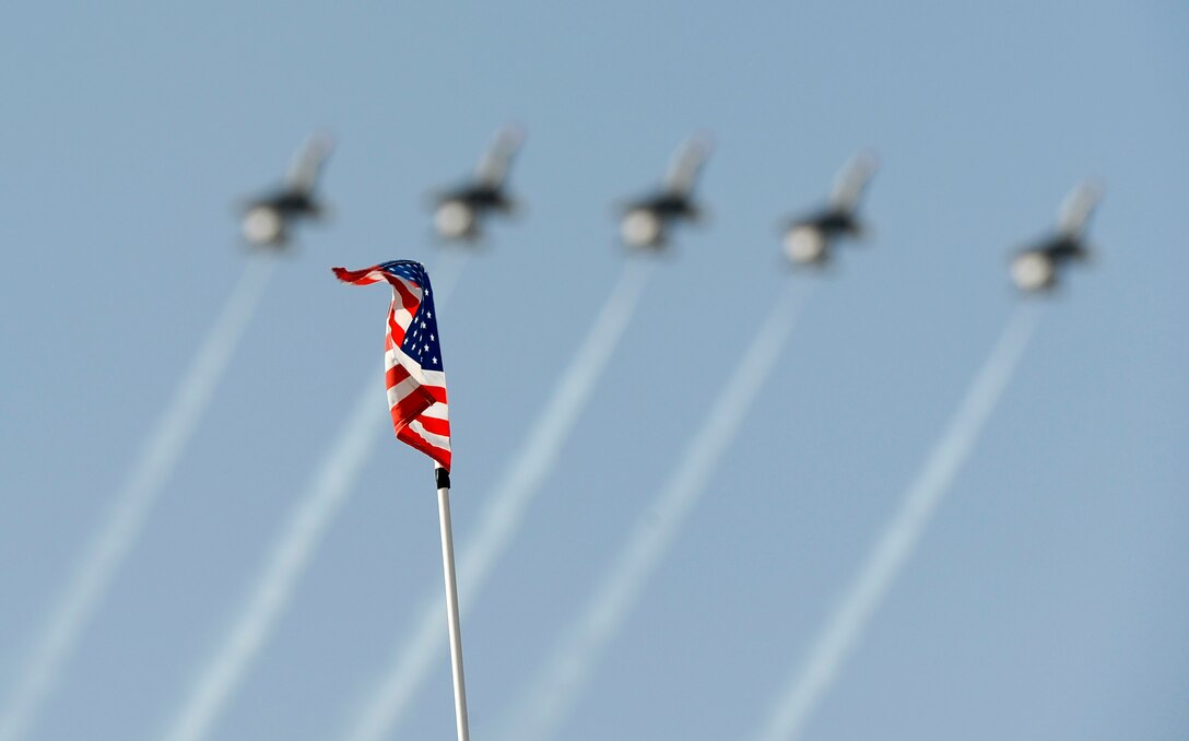 A gust of wind waves an American flag as the U.S. Air Force Air Demonstration Squadron, the Thunderbirds, perform during Air Power day at Osan Air Base, Republic of Korea, Oct. 21. (U.S. Air Force photo/Staff Sgt. Brian Ferguson)



