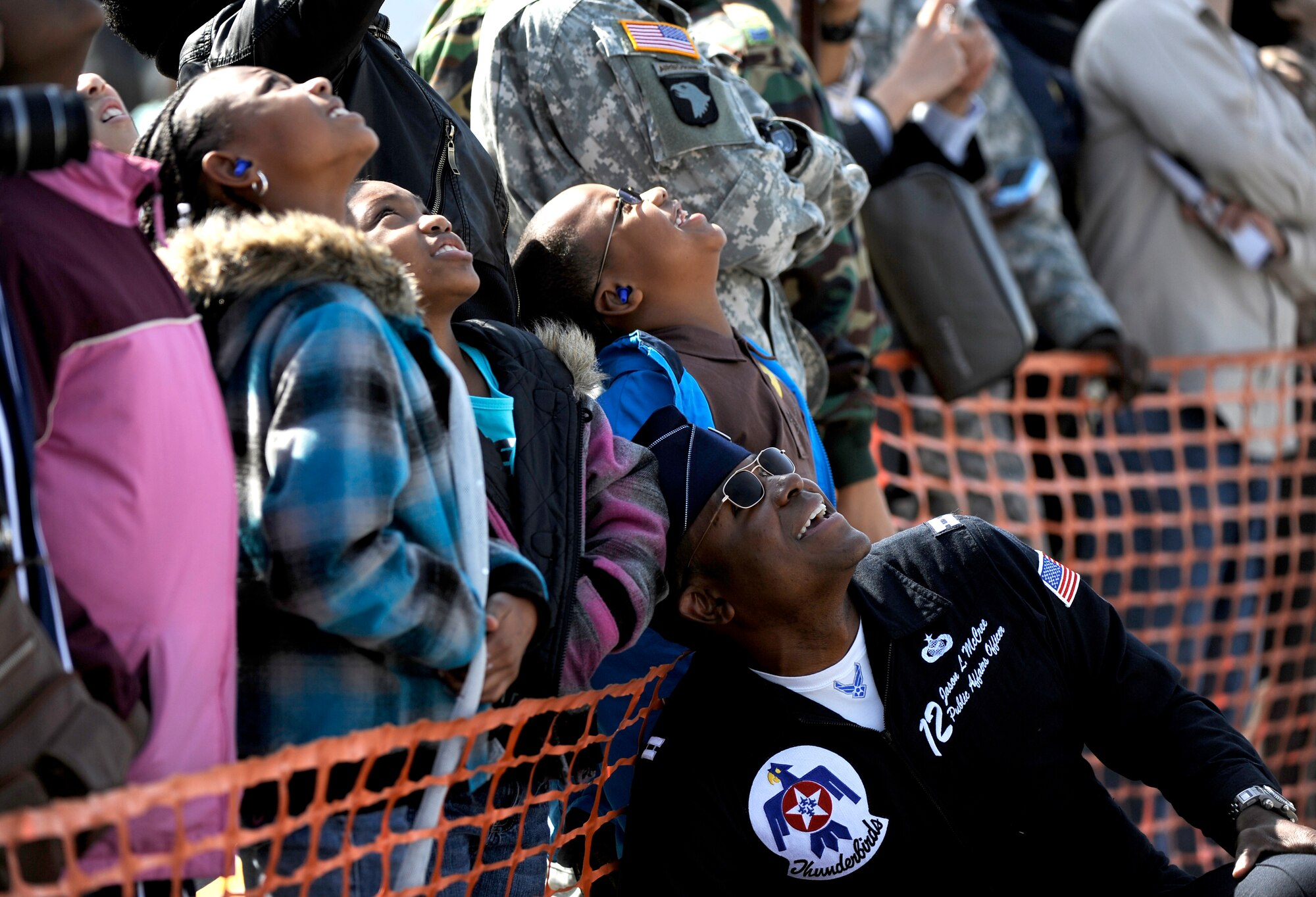 U.S. Air Force Thunderbird Capt. Jason L. McCree watches the aerial demonstration with a group of young spectators during Air Power Day 2009 at Osan Air Base, Republic of Korea, Oct. 21.  Captain McCree is the public affairs officer for the team. (U.S. Air Force photo/Staff Sgt. Brian Ferguson)




