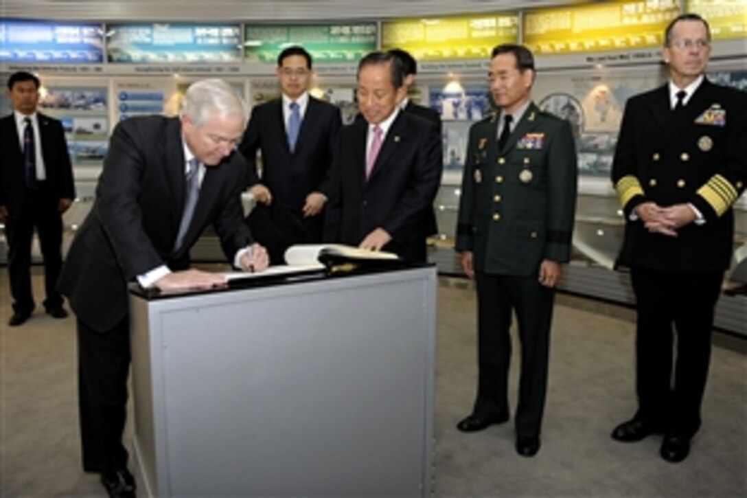 U.S. Defense Secretary Robert M. Gates signs a guest book at the Korean Ministry of Defense with South Korean Defense Minister Kim Tae-young in Seoul, Republic of South Korea, Oct. 22, 2009. 