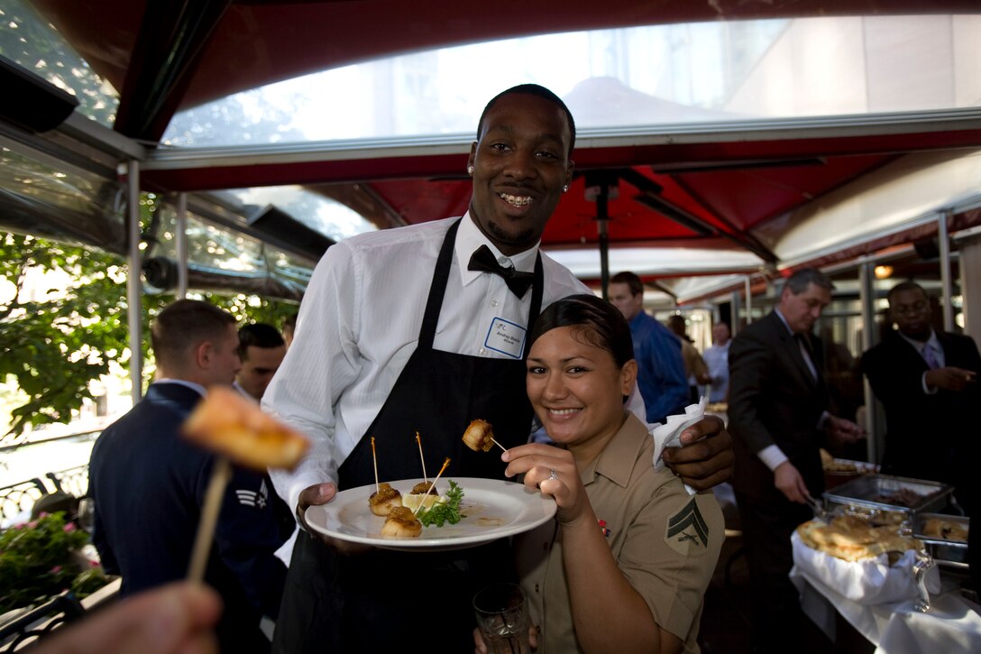 Andray Blatche, Washington Wizards basketball player, takes a break from serving food to meet with Cpl. Poppy King, supply warehouse clerk, Marine Barracks Washington, during the "Salute to the Stars" luncheon at Morton's The Steak House in Washington, Oct. 21. The Wizards hosted service members to a generous feast to honor them and the sacrifices they make to protect the nation.