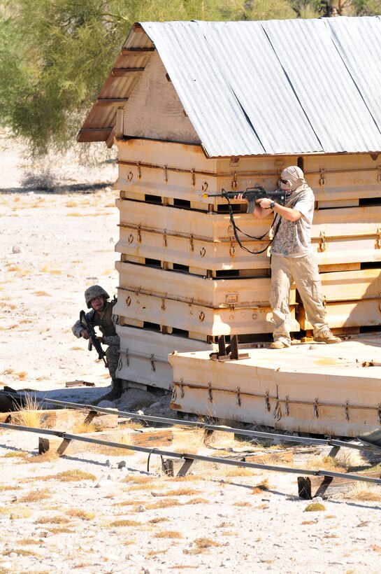 A Corporal’s Course student prepares to engage Petty Officer 2nd Class Daniel Hagerty, role playing insurgent, Oct. 22, 2009, on the Barry M. Goldwater Range during a field exercise. The class, which graduated Oct. 23, 2009, spent the day patrolling through a mock Middle Eastern village during the course’s final exercise.