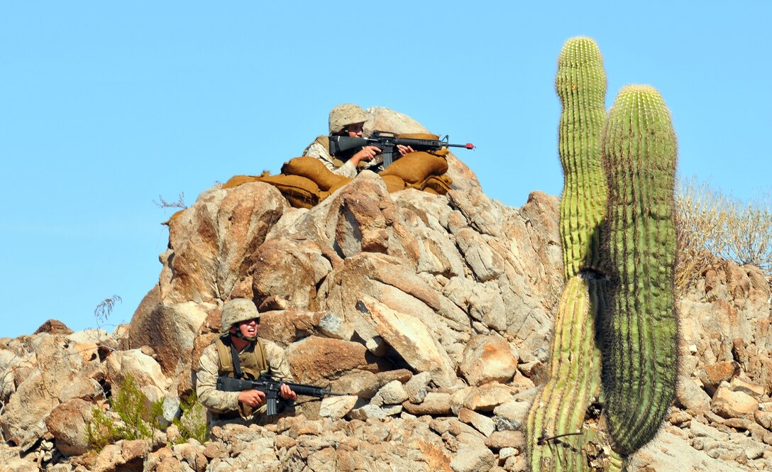 During their final exercise, two Corporal’s Course students take position on a hill on the  Barry M. Goldwater Range Oct. 22, 2009. This was the first Corporal’s Course held at the air station using the revised curriculum mandated throughout the Corps. The 35 students graduated Oct. 23, 2009.