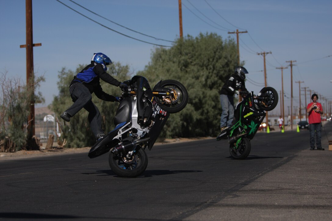 Eric Whitcomb (right), a stunt rider for the Speed Channel, and Kyle Rappaport, a stunt rider at the Marine Corps Communications-Electronic School Safety Fair, perform circles on Bourke Street during the MCCES Safety Fair Oct. 23. The riders spoke to the audience of MCCES students and instructors about safe driving.