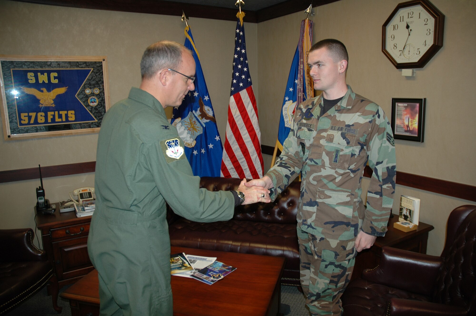 Col. Michael Fortney, 341st Missile Wing commander, congratulates Senior Airman James Broderick, 341st Missile Maintenance Squadron top-sider, Sept. 14 in the 341st MW command suite for completing more than 100 incident-free missions to the Malmstrom's missile complex behind the wheel of a payload transporter van. Colonel Fortney thanked Airman Broderick for his level of attention and said nothing is more important than the mission that Malmstrom Airmen perform every day. (U.S. Air Force photo/Senior Airman Dillon White)