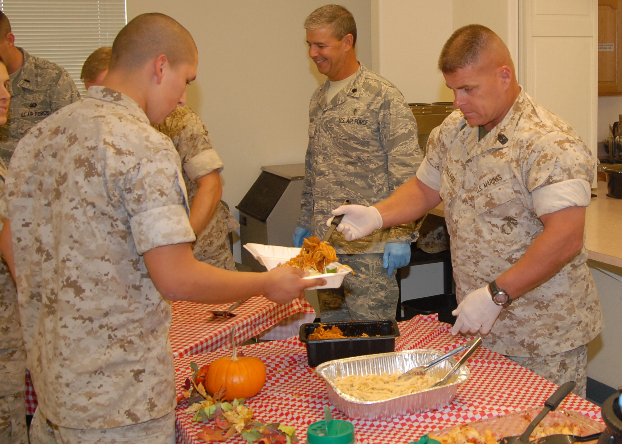 Marine Sgt. Maj. Christopher Dillree (right), Marine Aircraft Group 41 Detachment A Sergeant Major, serves a Marine during the Dorm Dwellers Dinner at the chapel 1 annex here Oct. 21. The dinner was hosted by Edwards Enlisted Spouses Club and was open to all dorm residents, both Air Force and Marine Corp. (Air Force photo/Airman 1st Class William O'Brien)