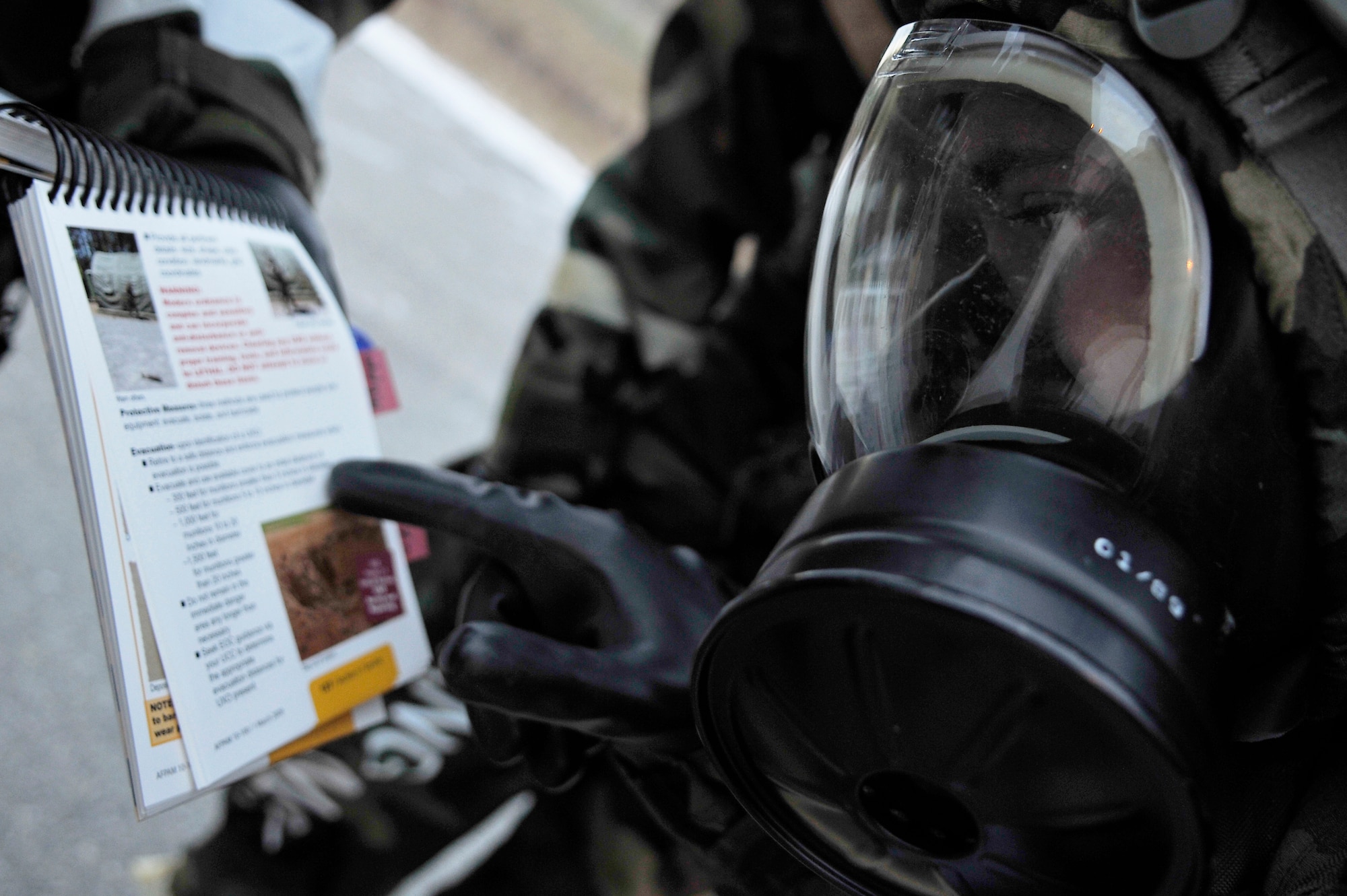 Airman 1st Class Andrew O'Brien looks through his Airman's Manual for instructions on how to properly cordon off unexploded ordnances during a training evaluation Oct. 23, 2009, Eielson Air Force Base, Alaska. The evaluation tests the ability of Airmen on how to survive and operate in a chemical, biological, radiological, nuclear and high yield explosive environment. Airman O'Brien is assigned to the 354th Maintenance Squadron. (U.S. Air Force photo/Staff Sgt. Christopher Boitz)