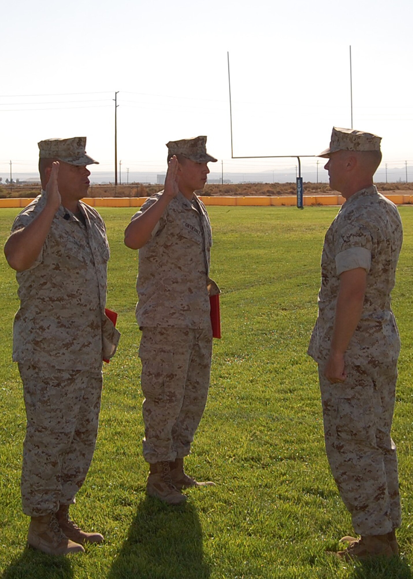 Marine Lt. Col. Christopher Keane (right), Marine Aircraft Group 46 Detachment Bravo commander reenlists Sgt. Maj. Christopher Dillree (left) MAG 46 Det B sergeant major and promotes Lance Corporal Oscar Gutierrez (center) during a ceremony at Wings Field Oct. 3. (Courtesy photo)