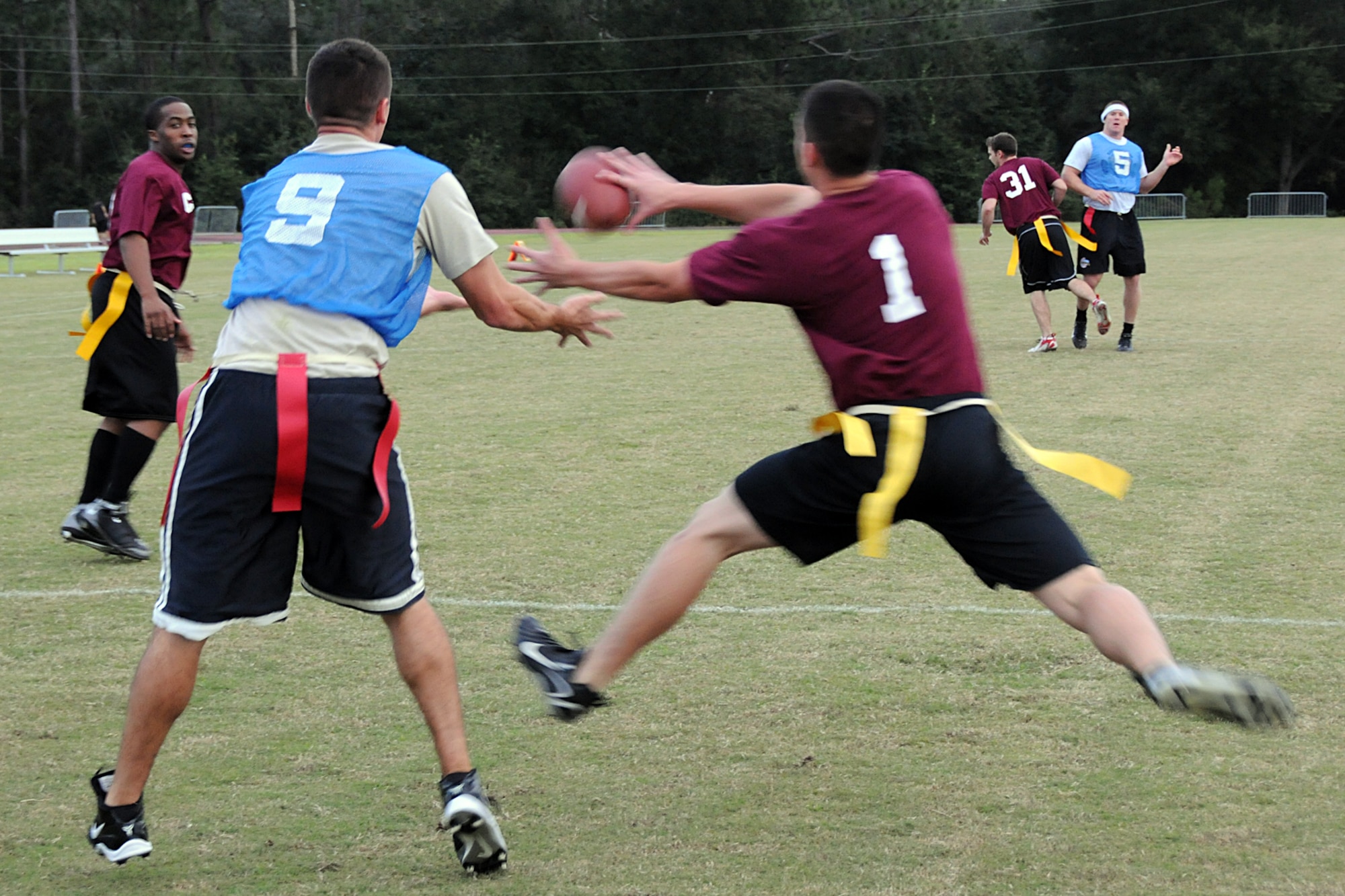EGLIN AIR FORCE BASE, Fla. --  Members from the 96th Communications group (burgundy shirts) and the 308th Armament Systems wing (blue jerseys) reach for a bullet passed into the end zone during an Intramural Flag Football matchup, Oct. 22. The 308th team beat the 96th Comm team 23-18 in a nail-biting contest which came down to the final seconds of the game. Games are played every Tuesday and Thursday at the East Gate track beginning at 5:30 p.m. (U.S. Air Force photo/Airman Anthony Jennings)
