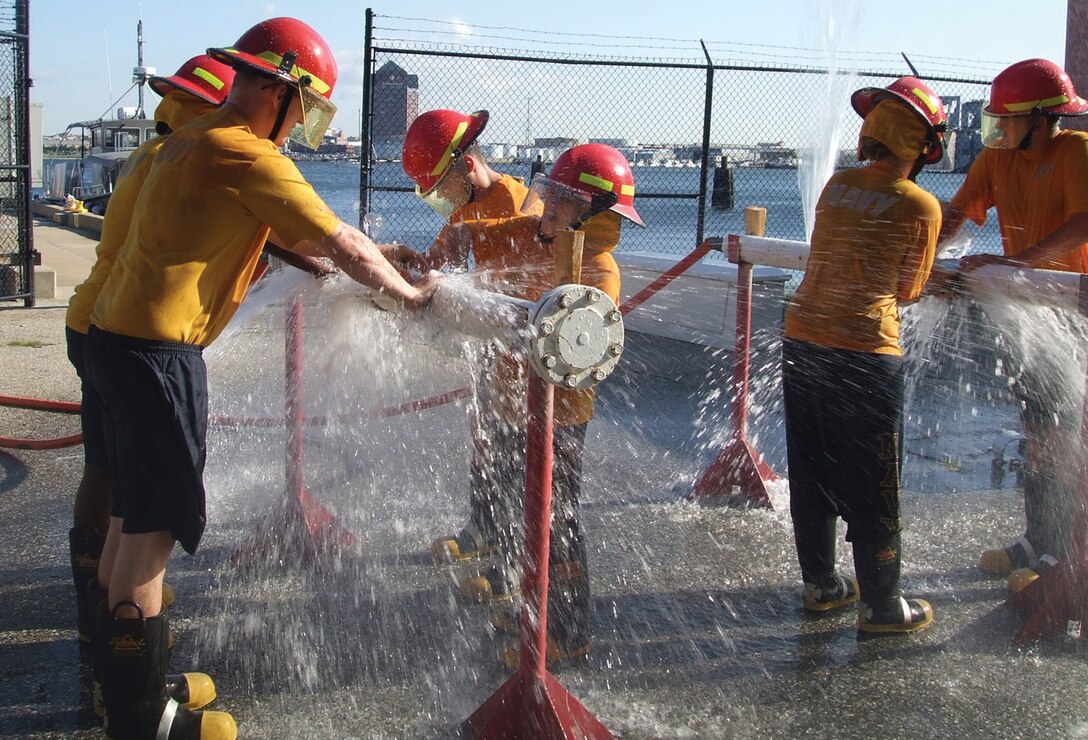 Several Sailors from Fleet Readiness Center Mid-Atlantic Washington perform pipe patching training during a simulated drill at Navy Operational Support Center Baltimore Oct. 7. The team of Sailors from FRC Mid-Atlantic received instruction on damage control procedures at the Damage Control Engineering Test Facility complex in Baltimore. The facility provides the Navy with a flexible, cost-effective facility to simulate and evaluate ship structure, equipment and procedures in multiple damage conditions. The simulated procedures and damage conditions include gaining compartment access, investigation, flooding, pipe damage, hull damage, cable damage, personnel tracking and rescue, smoke spread, emergency communications and plotting. (U.S. Air Force photo/ LS2(SW) Teddy Jnbaptiste)