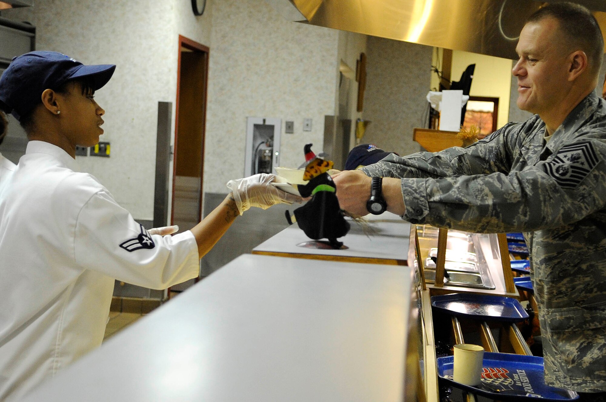 Airman 1st Class Tiara Taylor, 28th Force Support Squadron food services journeyman, hands breakfast to Chief Master Sgt. of the Air Force James A. Roy, Oct. 22, 2009, during his two-day visit to Ellsworth Air Force Base, S.D.  Chief Roy ate breakfast with recent graduates of Airmen Leadership School and discussed various high-interest Air Force topics.  (U.S. Air Force photo/Airman 1st Class Corey Hook)