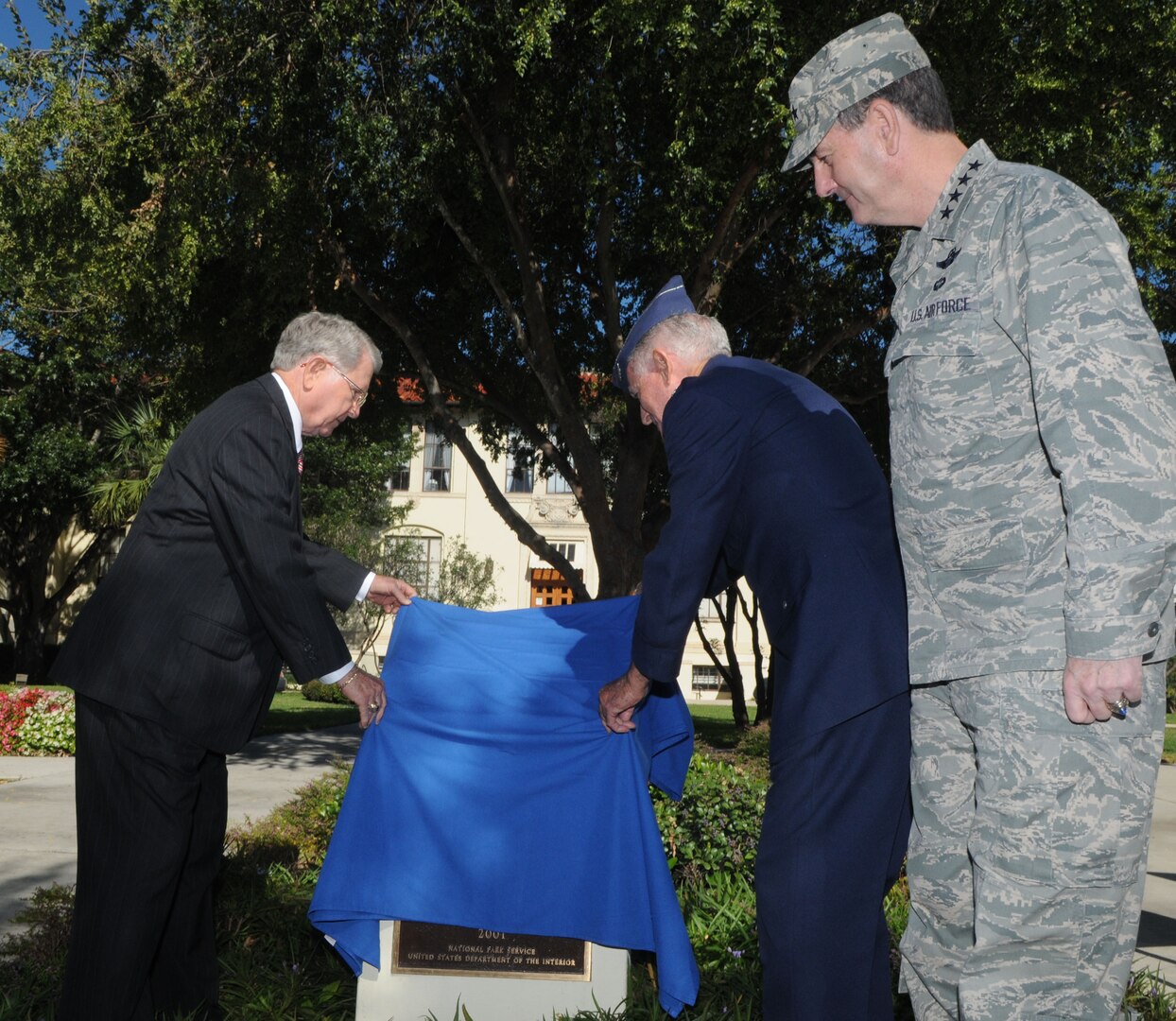 Gen. Stephen Lorenz, Air Education and Training Command commander, looks on as former Randolph Air Force Base cadets, Maj. Gen. (retired) William Acker, left, and Col. (retired) Donald Robison, unveil the plaque at the Cadet Circle dedication ceremony in the AETC circle drive. The circular courtyard between the AETC headquarters building and the command’s Lahm Conference Center was named Cadet Circle today to honor more than 16,000 aviation cadets and student pilots who received their pilot training here.  The Army Air Corps Aviation Cadet Program began during World War I and was conducted at Randolph from 1931 to 1965.  In 1943 the mission here changed when the Central Instructor's School moved to Randolph. In 1947 the cadets came back along with basic flying training and remained here until cadet training was phased out at Randolph in 1951. The new monument, centered in the middle of the courtyard, honors the men who were the primary reason for the existence of the base itself—cadets who lived, trained, and in some cases, died at Randolph. (U.S. Air Force/ Rich McFadden) 