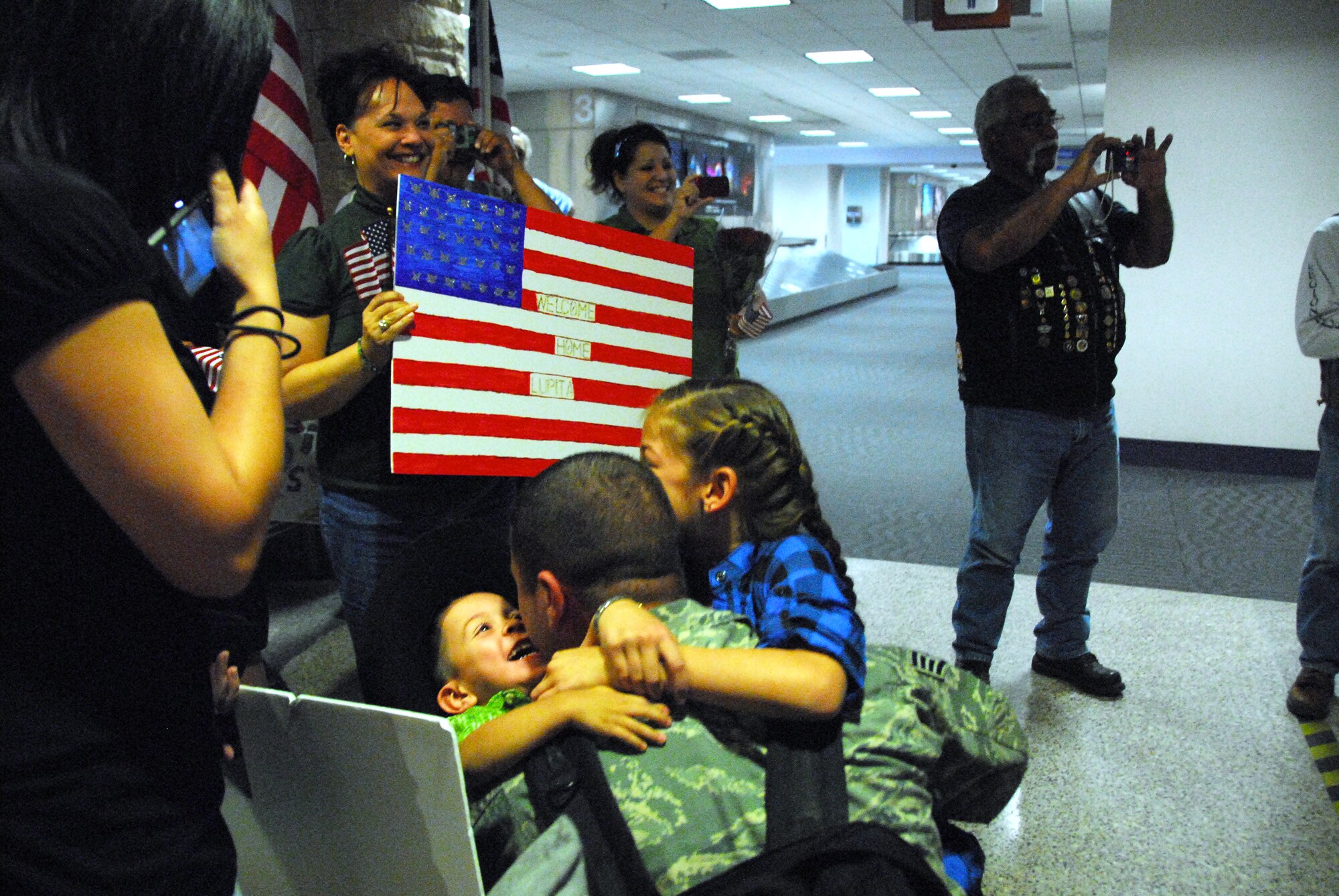 Staff Sgt. Eric Klajda, 162nd Force Support Squadron, is greeted by family in the Tucson Airport baggage claim after a four-month deployment to Southwest Asia, Oct. 22.   (Air National Guard photo by Master Sgt. David Neve)