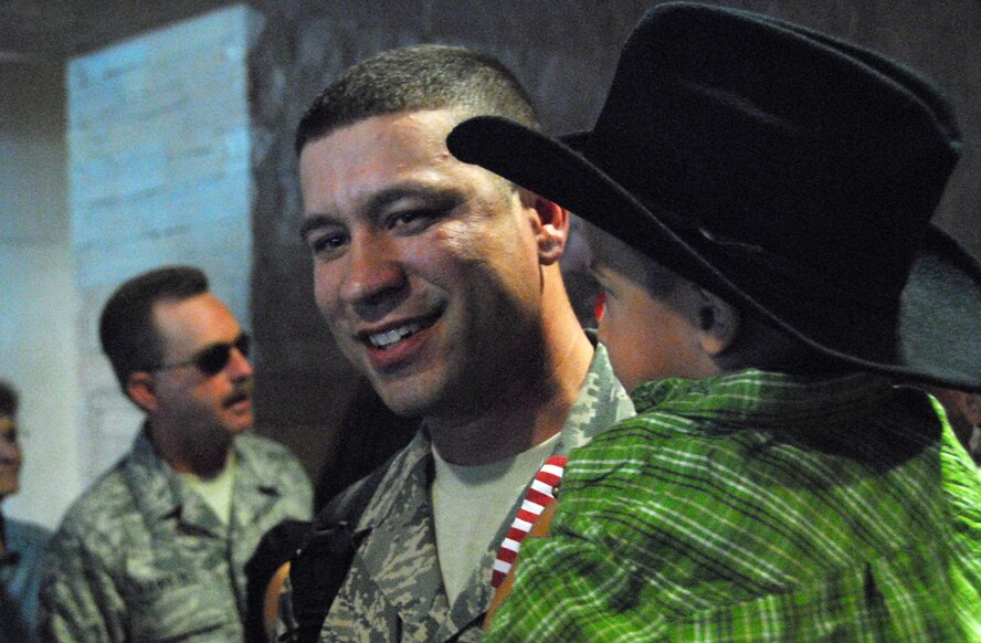 Staff Sgt. Eric Klajda, 162nd Force Support Squadron, is greeted by family in the Tucson Airport baggage claim after a four-month deployment to Southwest Asia, Oct. 22.  (Air National Guard pphoto by Master Sgt. David Neve)