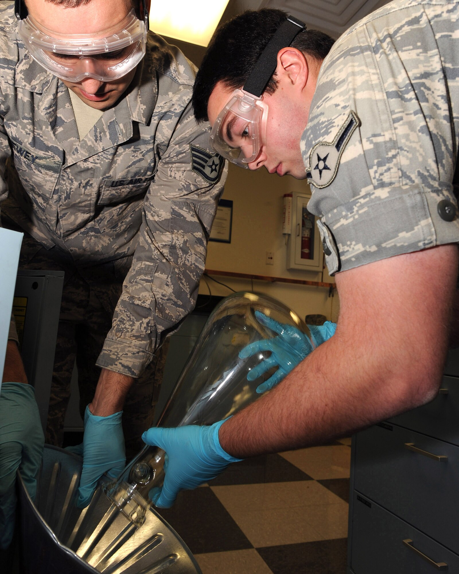 Airman Lucas Berg pours excess JP-8 fuel into a funnel held by Staff Sgt. Clint Lewey Oct. 21, 2009, at Little Rock Air Force Base. Ark. The fuels lab technicians are responsible for making sure the fuel is checked for quality, cleanliness, and the mixture of the fuel is within specifications. Airman Berg and Sergeant Lewey are assigned to the 19th Logistics Readiness Squadron. (U.S. Air Force photo/Staff Sgt. Chad Chisholm) 