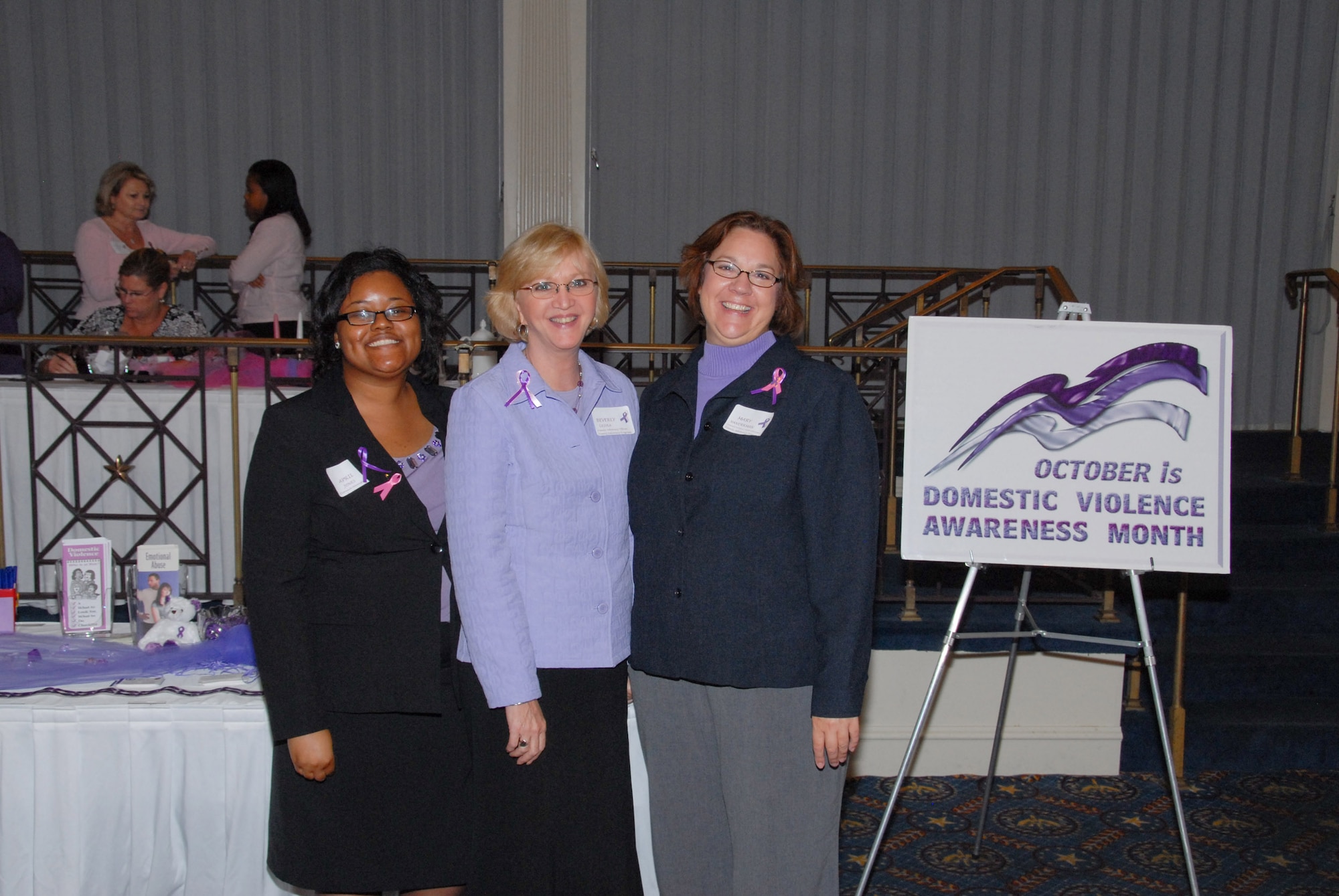 At top, guest speakers for the “Pink and Purple” luncheon included (from left) April Jones, Family Advocacy Program outreach manager; Beverly Lesyea, Family Advocacy Program officer; and Mary Vanderman, Family Advocacy Program domestic violence victim advocate. (U.S. Air Force photo/Roger Curry) 
