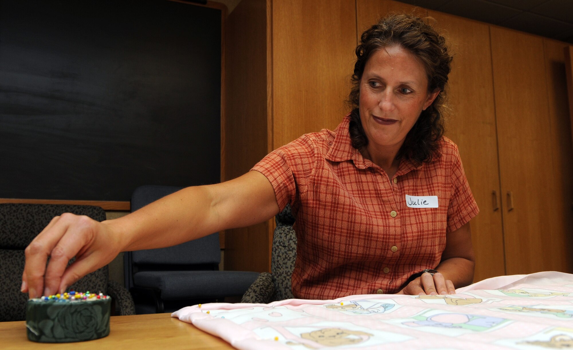 MOUNTAIN HOME AIR FORCE BASE, Idaho -- Maj. Julie Ostrand, 366th Surgical Operations Squadron and Hammond Baby Bundles volunteer, pins fabric to make a quilt during Hammond Quilt Day Oct. 17 at the Airman and Family Readiness Center. Volunteers assembled more than two dozen quilts to donate to families with newborn babies at the 366th Medical Group Family Care Unit. Hammond Quilt Day began in 2004 to honor the memory of Airman 1st Class Walter James Hammond IV, who was an avid volunteer. (U.S. Air Force photo by Airman 1st Class Debbie Lockhart)