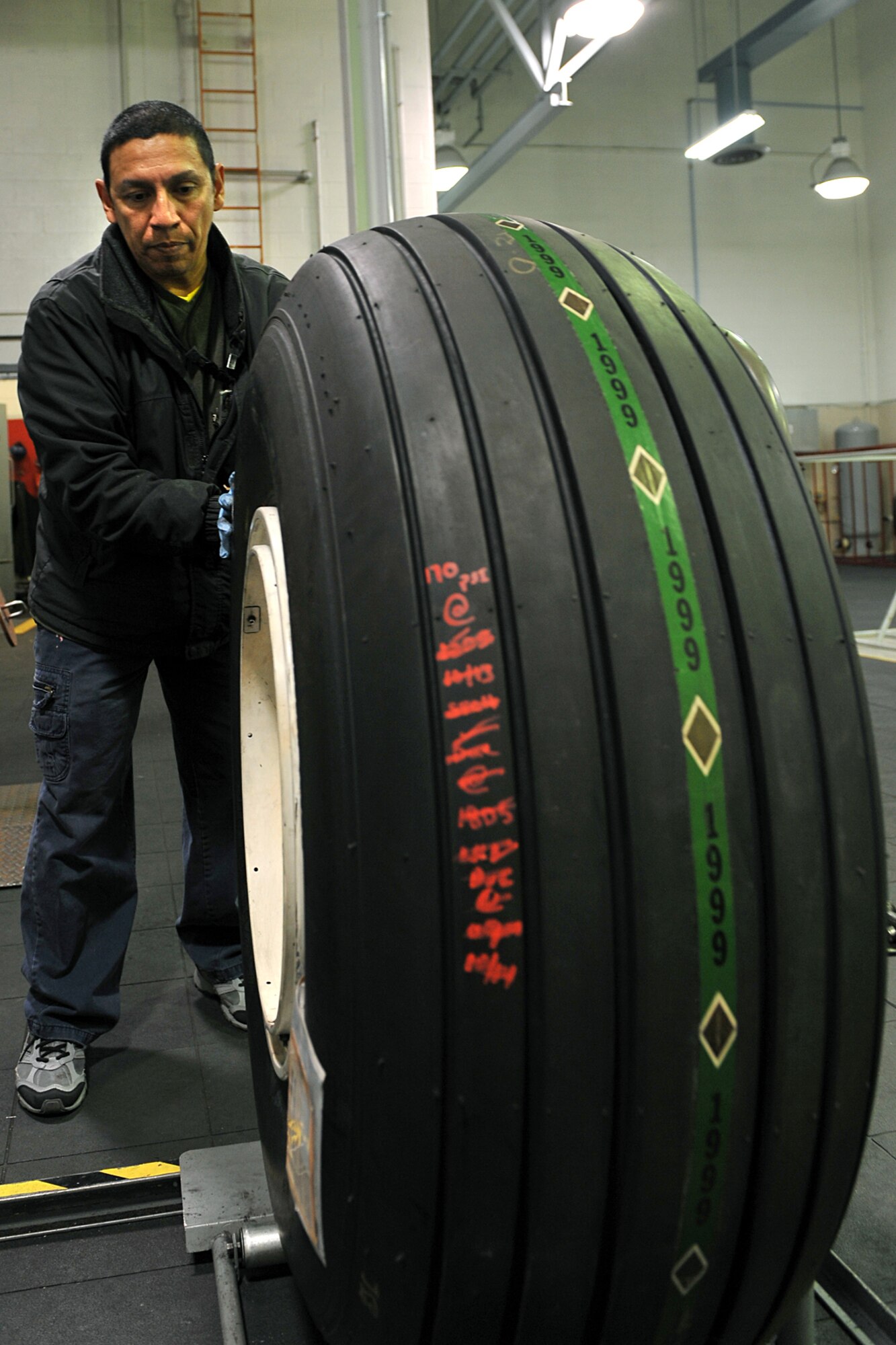OFFUTT AIR FORCE BASE, Neb. - Greg Sanchez, an aircraft mechanic in the 55th Maintenance Squadron's isochronal phase inspection dock here, pushes a tire on to a universal wheel build up machine in the wheel and tire shop Oct. 15. In addition to working in the ISO dock in the Bennie Davis Maintenance Facility, the approximately 40 aircraft mechanics also man the wheel and tire back shop when necessary. Each year they process about 400 wheels and tires for the C-135 variant and E-4B aricraft assigned here.

U.S. Air Force photo by Charles Haymond 
