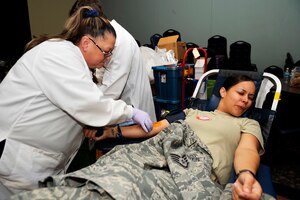MOUNTAIN HOME AIR FORCE BASE, Idaho -- Staff Sgt. Jessica Rosario-Styles, 366th  Logistics Readiness Squadron, reacts as Dorothy Lane, Red Cross technician, inserts a needle into her arm during a blood drive Oct. 22 at the Community Center. The 366th Fighter Wing collected 121 units of blood, beating the previous record of blood donated in one day by eight units. (U.S. Air Force photo by Senior Airman Samantha Crane)