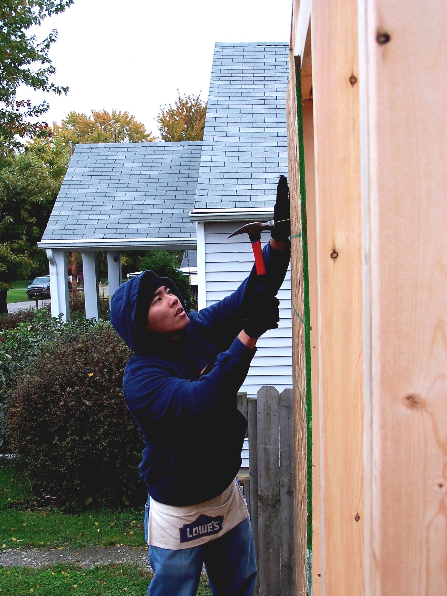 Senior Airman Joneal Alop hammers in a nail to sure the outer wall of the Habitat for Humanity house the 88th Security Forces members helped to erect.