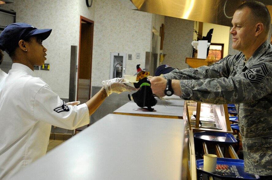 ELLSWORTH AIR FORCE BASE, S.D.-- Airman 1st Class Tiara Taylor, 28th Force Support Squadron food services journeyman, hands breakfast to Chief Master Sgt. of the Air Force James A. Roy, Oct. 22. Chief Roy ate breakfast and discussed several topics in the Air Force today with the graduating Airmen Leadership Class during the second day of his visit. (U.S. Air Force photo/Airman 1st Class Corey Hook)