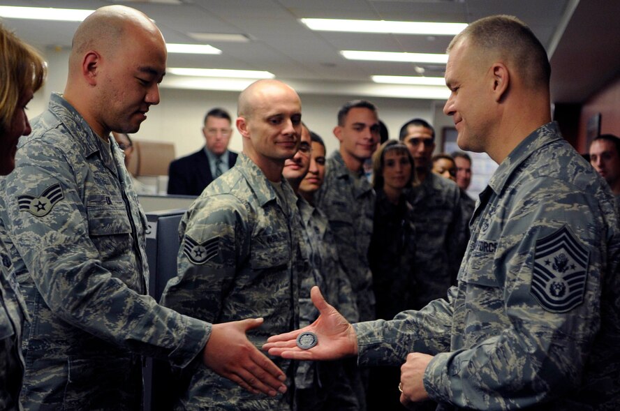 ELLSWORTH AIR FORCE BASE, S.D.-- Chief Master Sgt. of the Air Force James A. Roy coins Senior Airman Mike Liu, Air Force Financial Services Center travel technician, Oct. 21. Senior Airman Liu was credited by Chief Roy for his work performance. (U.S. Air Force photo/Airman 1st Class Corey Hook)
