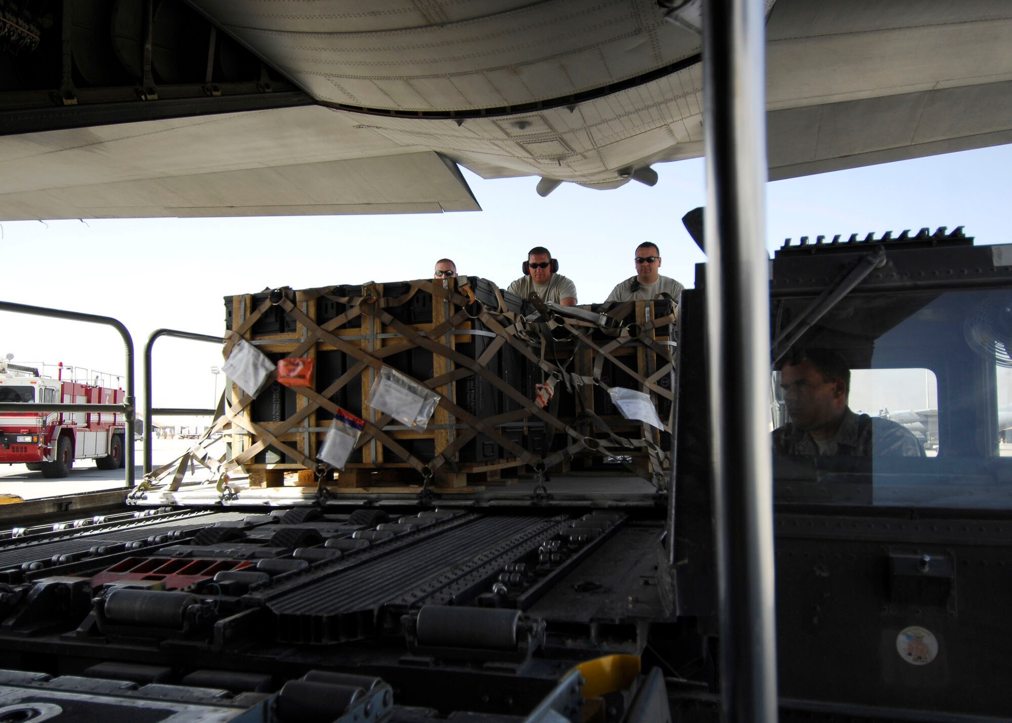 BAGRAM AIRFIELD, Afghanistan -- From left to right Staff Sgt. Joe Brummett, Master Sgt. Shannon Koenigstein and Tech. Sgt. Pete Cervantez, all air transportation specialists from the 455th Expeditionary Aerial Port Squadron, push pallets of ammunition onto a C-130 Hercules, Oct. 23, 2009.  Sergeant Brummett and Sgt. Cervantez are deployed from Lackland Air Force Base, Texas.  Sergeant Brummett hails from San Antonio, and Sgt. Cervantez hails from Del Rio, Texas.   Sergeant Koenigstein is deployed from McGuire AFB, N.J., and hails from Glennville, Ga.  (U.S. Air Force photo/Senior Airman Felicia Juenke)