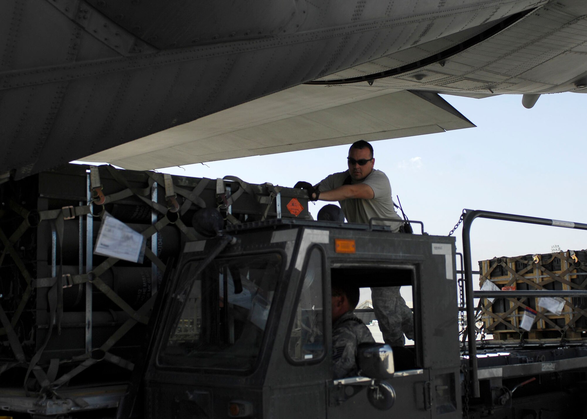 BAGRAM AIRFIELD, Afghanistan -- Tech. Sgt. Pete Cervantez, an air transportation specialist from the 455th Expeditionary Aerial Port Squadron, assists his fellow Airmen by pushing pallets of ammunition onto a C-130 Hercules, Oct. 23, 2009.  Sergeant Cervantez is deployed from Lackland Air Force Base, Texas, and hails from Del Rio, Texas.  (U.S. Air Force photo/Senior Airman Felicia Juenke)