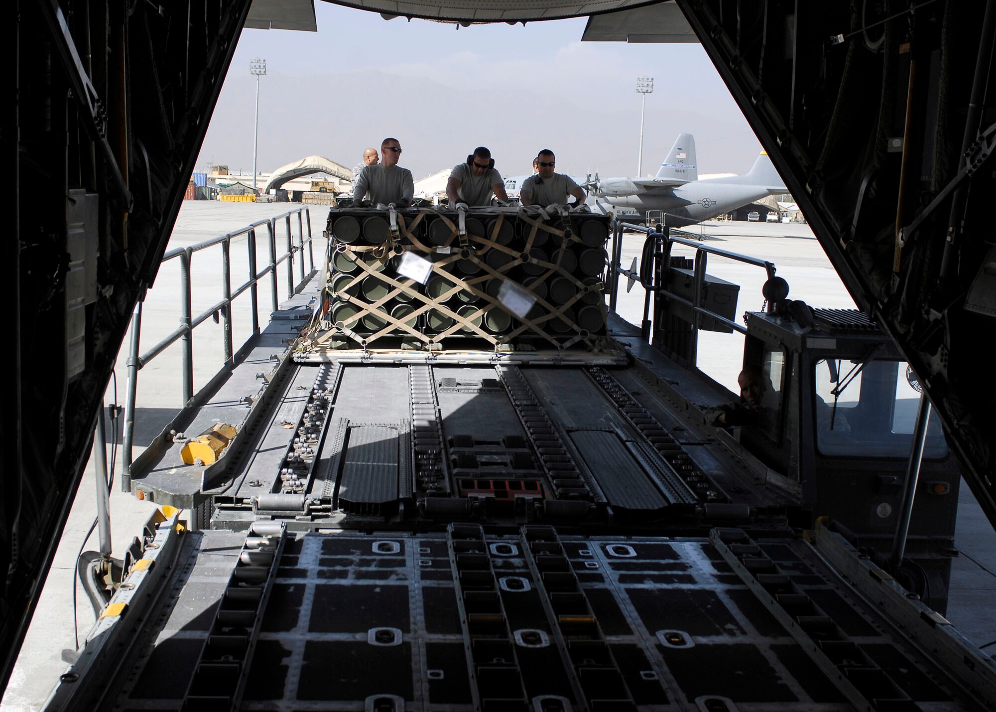 BAGRAM AIRFIELD, Afghanistan -- From left to right Staff Sgt. Joe Brummett, Master Sgt. Shannon Koenigstein, and Tech. Sgt. Pete Cervantez, all air transportation specialists from the 455th Expeditionary Aerial Port Squadron, push pallets of ammunition onto a C-130 Hercules, Oct. 23, 2009.  Sergeant Brummett and Sergeant Cervantez are deployed from Lackland Air Force Base, Texas.  Sergeant Brummett hails from San Antonio, and Sgt. Cervantez hails from Del Rio, Texas.   Sergeant Koenigstein is deployed from McGuire AFB, N.J., and hails from Glennville, Ga.  (U.S. Air Force photo/Senior Airman Felicia Juenke)