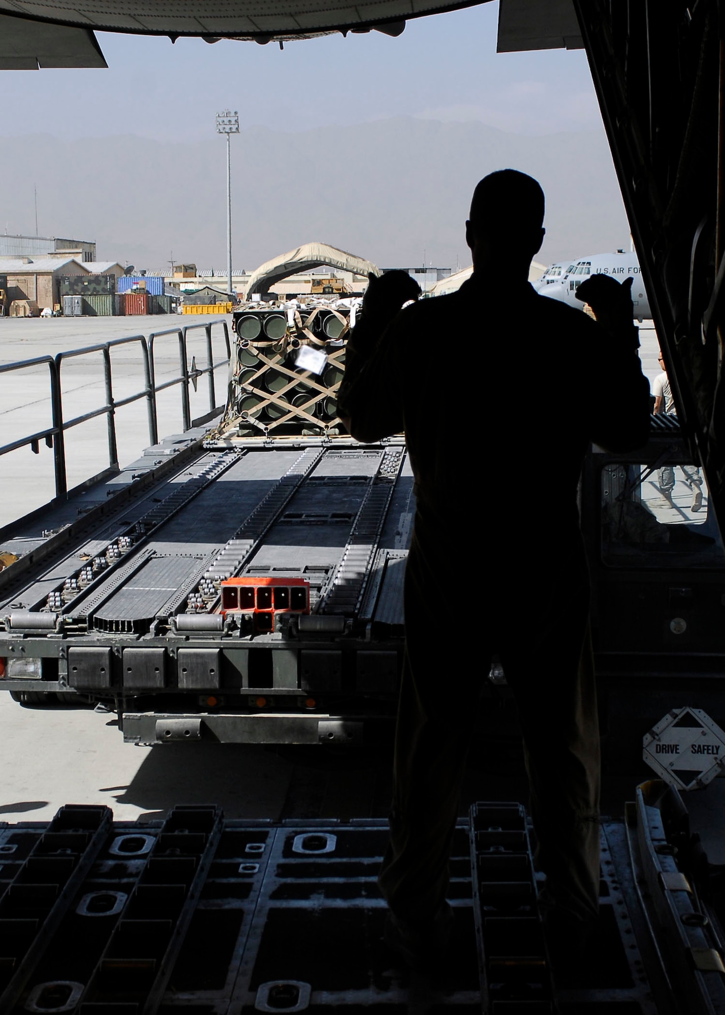 BAGRAM AIRFIELD, Afghanistan -- Staff Sgt. Terry Ellison (right), a loadmaster from the 774th Expeditionary Airlift Squadron, gives directions to Tech. Sgt. Mark Foreman (driver), Oct. 23, 2009.  Sergeant Ellison is deployed from the Texas Air National Guard's 136th Airlift Wing and hails from Fort Worth, Texas.  Sergeant Foreman, an air transportation specialist from the 455th Expeditionary Aerial Port Squadron, is deployed from Lackland Air Force Base, Texas and hails from San Antonio.  (U.S. Air Force photo/Senior Airman Felicia Juenke)