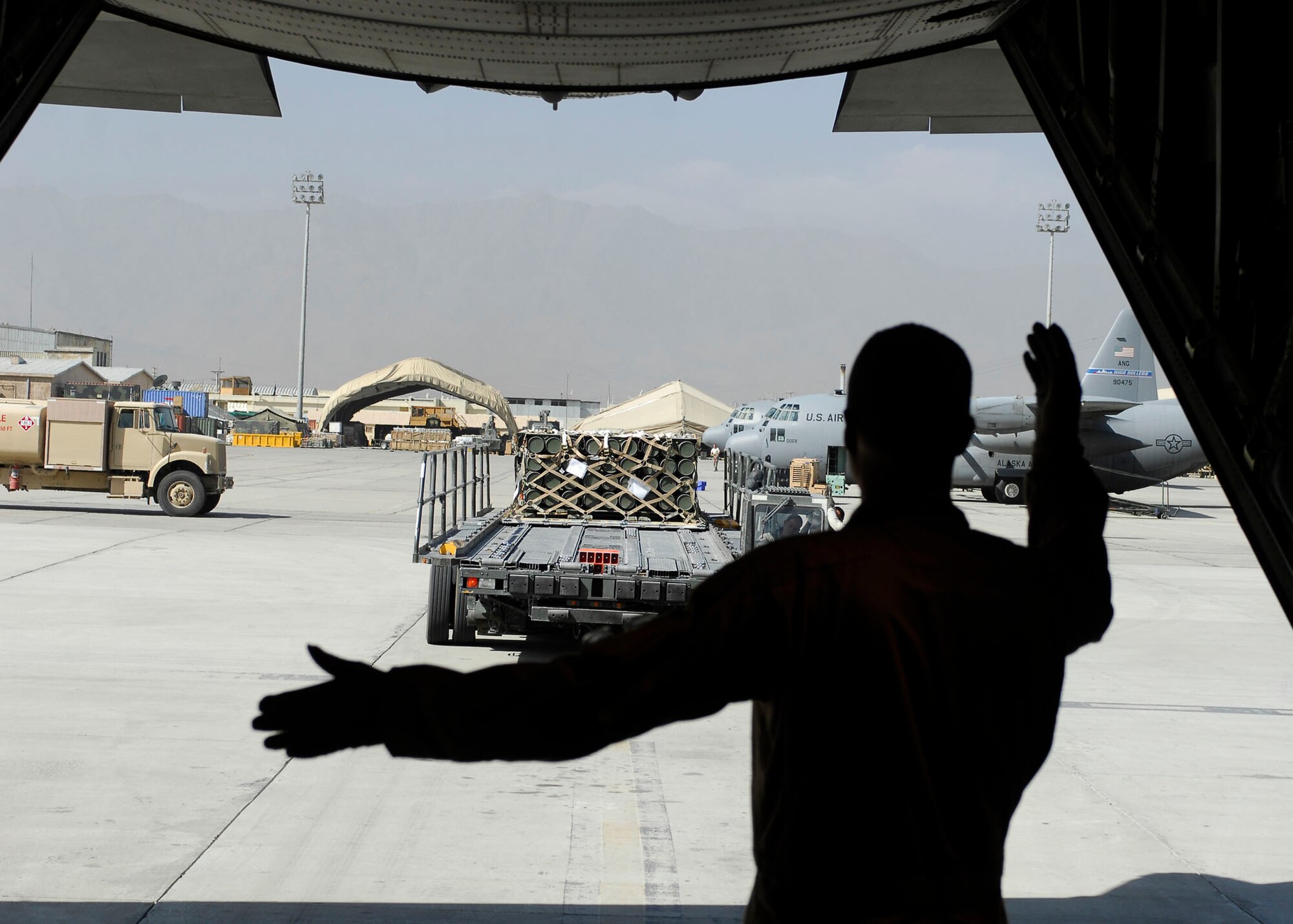 BAGRAM AIRFIELD, Afghanistan -- Staff Sgt. Terry Ellison (right), a loadmaster from the 774th Expeditionary Airlift Squadron, gives directions to Tech. Sgt. Mark Foreman (driver), Oct. 23, 2009.  Sergeant Ellison is deployed from the Texas Air National Guard's 136th Airlift Wing and hails from Fort Worth, Texas.  Sergeant Foreman, an air transportation specialist from the 455th Expeditionary Aerial Port Squadron, is deployed from Lackland Air Force Base, Texas and hails from San Antonio.  (U.S. Air Force photo/Senior Airman Felicia Juenke)