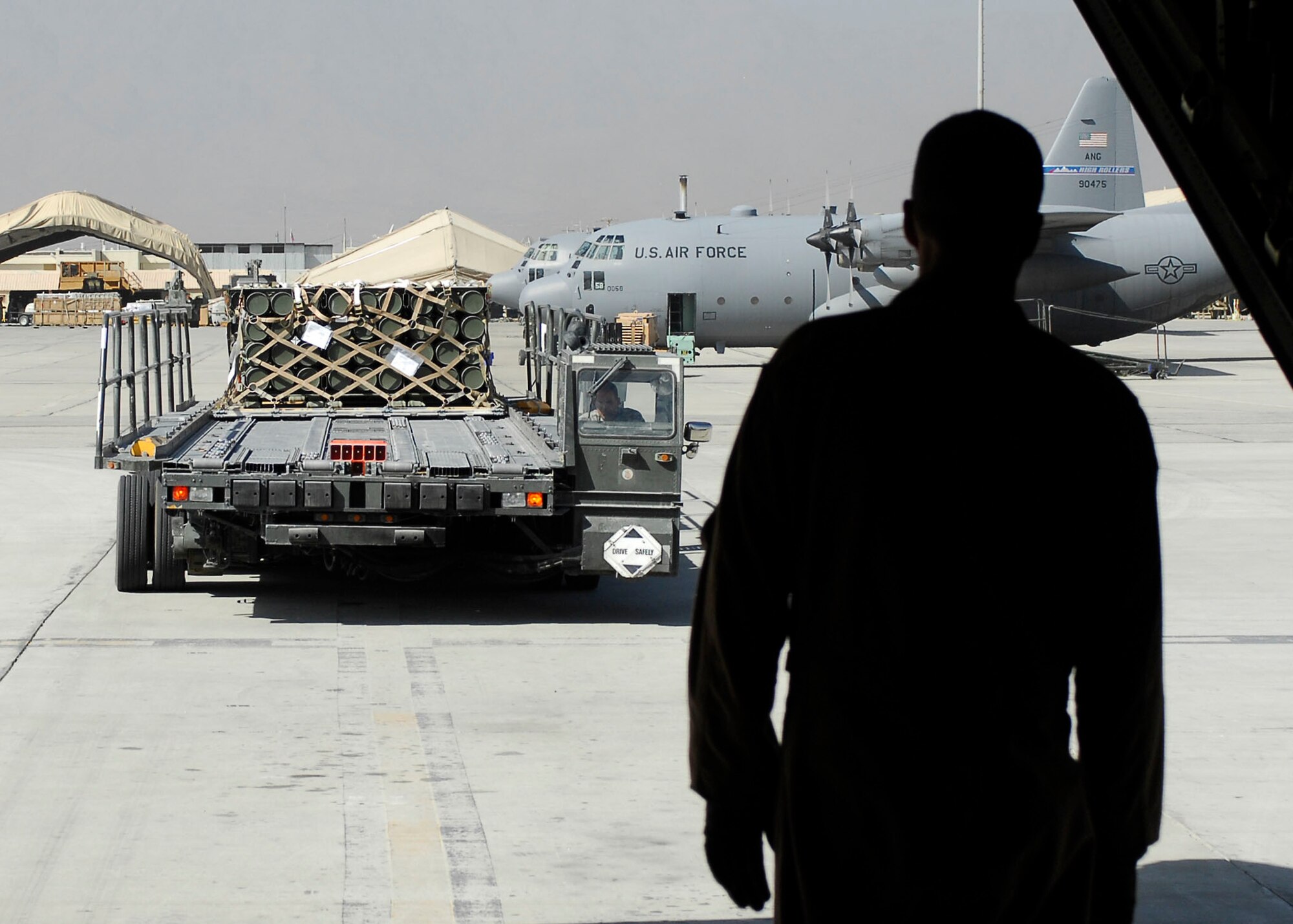 BAGRAM AIRFIELD, Afghanistan -- Staff Sgt. Terry Ellison (right), a loadmaster from the 774th Expeditionary Airlift Squadron, waits to give directions to Tech. Sgt. Mark Foreman (driver), Oct. 23, 2009.  The Airmen are important to re-supply missions by loading all the equipment necessary for any contingency.  Sergeant Ellison is deployed from the Texas Air National Guard's 136th Airlift Wing and hails from Fort Worth, Texas.  Sergeant Foreman, an air transportation specialist from the 455th Expeditionary Aerial Port Squadron, is deployed from Lackland Air Force Base, Texas and hails from San Antonio.  (U.S. Air Force photo/Senior Airman Felicia Juenke)