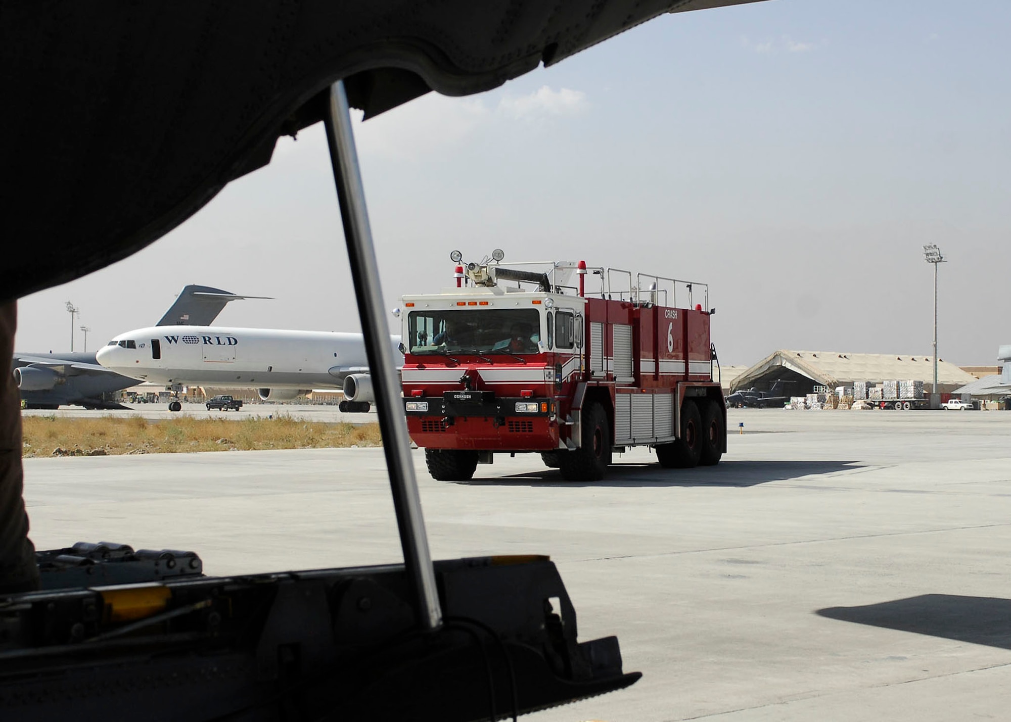 BAGRAM AIRFIELD, Afghanistan -- Firefighters from a Bagram Airfield Fire Department stand-by while Airmen load ammunition onto a C-130 Hercules, Oct. 23, 2009.  The firefighters are on-scene to ensure there are no problems while loading the ammunition.  (U.S. Air Force photo/Senior Airman Felicia Juenke)