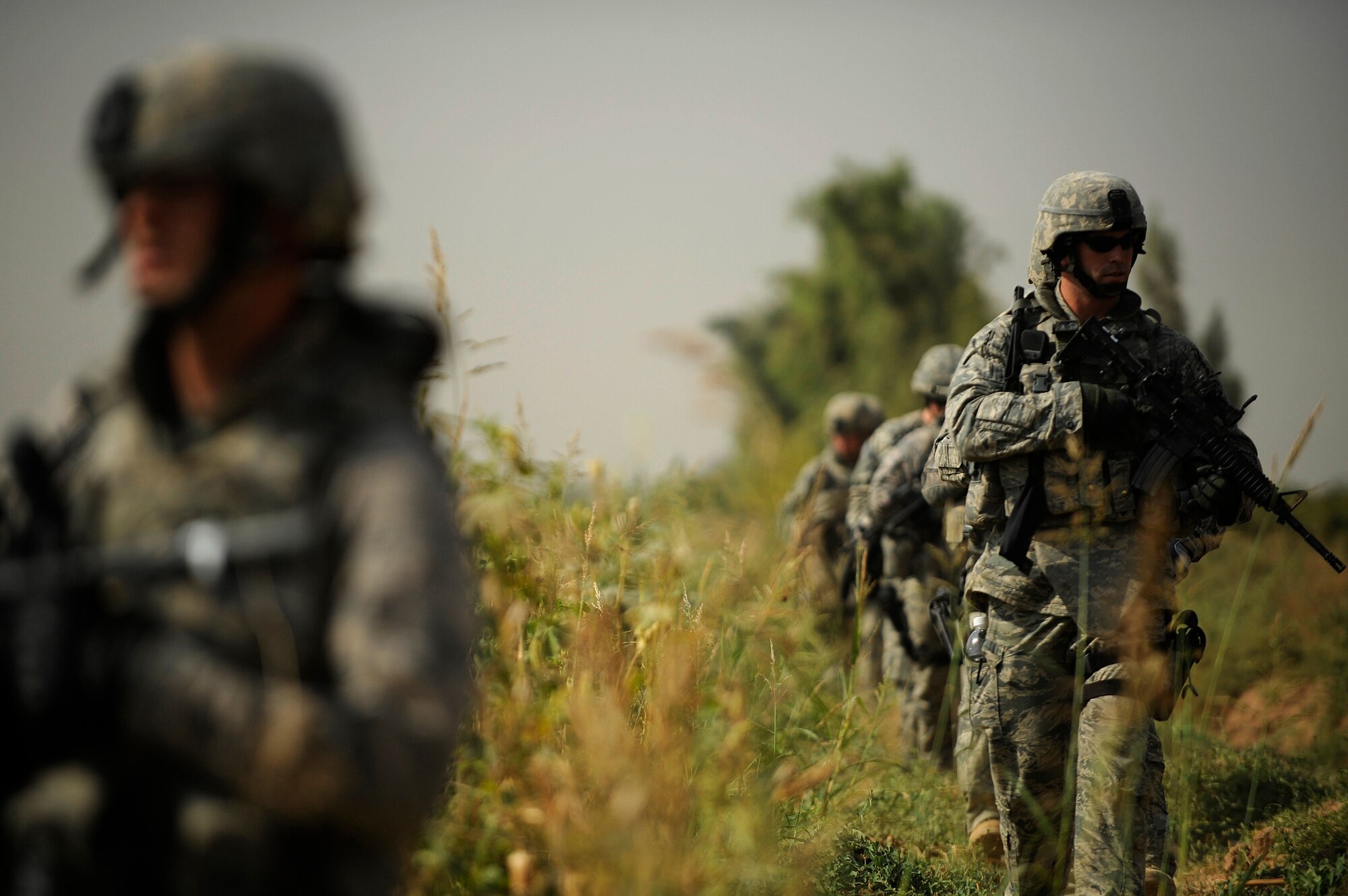 JOINT BASE BALAD, Iraq -- "Lion Team" Airmen from the 532nd Expeditionary Security Forces Squadron search a field during a Force protection patrol outside the base Oct. 17, 2009. The 532nd ESFS patrols outside JBB to provide a security presence intended to deter anyone who would do harm to the people who live and work here. (U.S. Air Force photo/Staff Sgt. Michael B. Keller) 