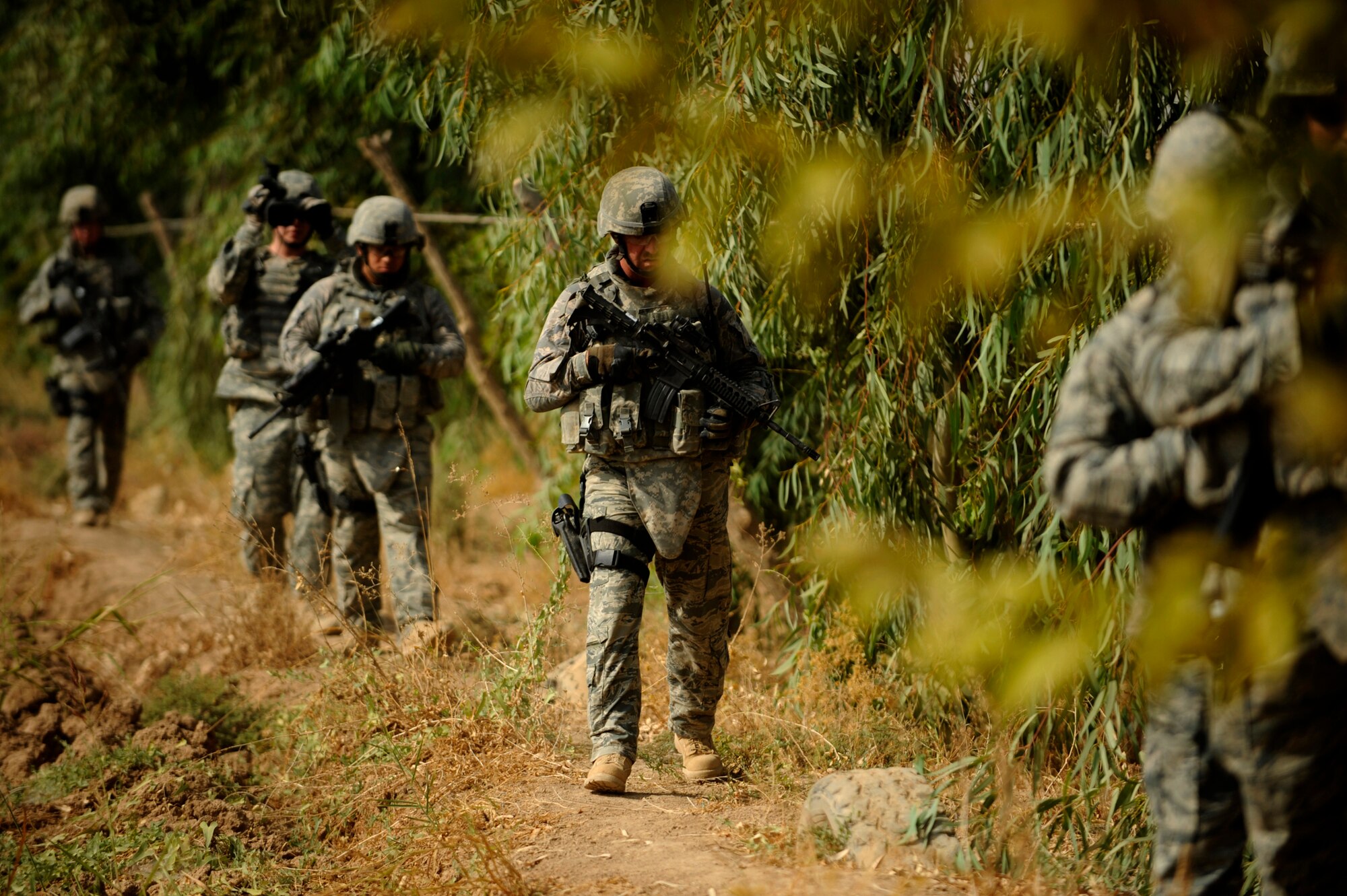 JOINT BASE BALAD, Iraq -- "Lion Team" Airmen from the 532nd Expeditionary Security Forces Squadron search a field during a Force protection patrol outside the base Oct. 17, 2009. The 532nd ESFS patrols outside JBB to provide a security presence intended to deter anyone who would do harm to the people who live and work here. (U.S. Air Force photo/Staff Sgt. Michael B. Keller) 