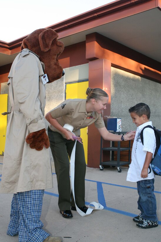 Cpl. Christina Thuman, a military police officer with Marine Corps Air Station Miramar’s Provost Marshal’s Office, and “McGruff,” the crime-fighting police dog, greet students as they arrive to Walker Elementary School Oct. 23.
