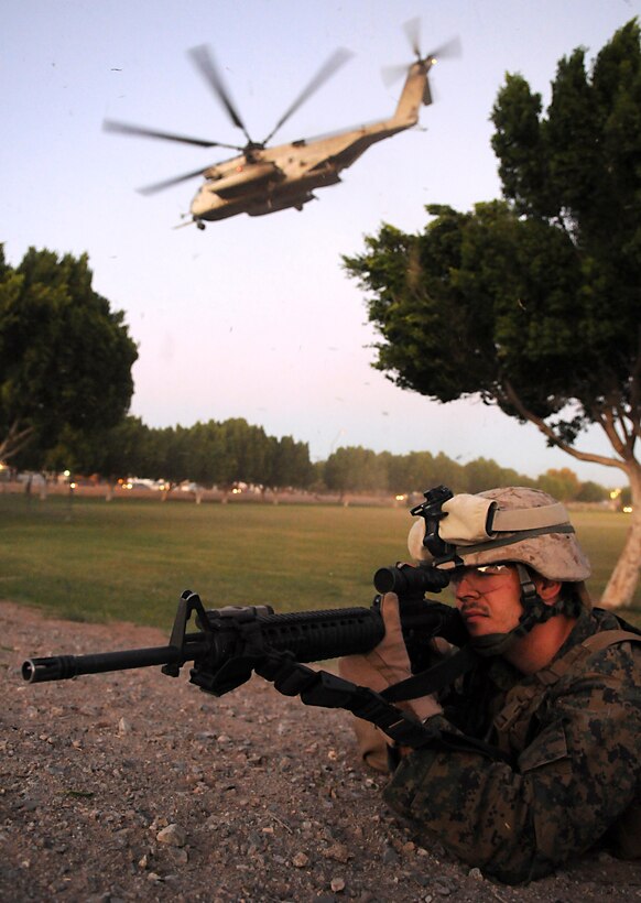 Petty Officer 3rd Class Stephen C. Fruge, Navy corpsman, defends the perimeter of a landing zone while a CH-53 Super Stallion helicopter takes off during a noncombatant evacuation exercise Oct. 23, 2009, in Kiwanis Park in Yuma, Ariz. The exercise is a part of the Weapons and Tactics Instructors course held twice a year at the Marine Corps Air Station in Yuma, Ariz. The course, run by Marine Aviation Weapons and Tactics Squadron 1, trains Marines from across the globe on the latest aviation tactics and techniques so they can then instruct members of their units. The city of Yuma allows the exercise to be held within city limits, which provides Marines with realistic training. Fruge, a 28-year-old native of Birmingham, Ala. is a member of Headquarters and Service Company, 1st Battalion, 2nd Marine Regiment. The battalion, based in Camp Lejeune, N.C., is training in Yuma for an upcoming deployment to Afghanistan.