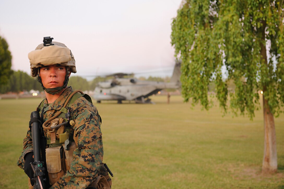 Cpl. Jesse E. Colio, weapon sights repairman, watches the perimeter of a landing zone while a CH-53 Super Stallion helicopter lands during a noncombatant evacuation exercise Oct. 23, 2009, in Kiwanis Park in Yuma, Ariz. The exercise is a part of the Weapons and Tactics Instructors course held twice a year at the Marine Corps Air Station in Yuma, Ariz. The course, run by Marine Aviation Weapons and Tactics Squadron 1, trains Marines from across the globe on the latest aviation tactics and techniques so they can then instruct members of their units. The city of Yuma allows the exercise to be held within city limits, which provides Marines with realistic training. Colio, a 21-year-old native of Modesto, Calif., is a member of Headquarters and Service Company, 1st Battalion, 2nd Marine Regiment. The battalion, based in Camp Lejeune, N.C., is training in Yuma for an upcoming deployment to Afghanistan.