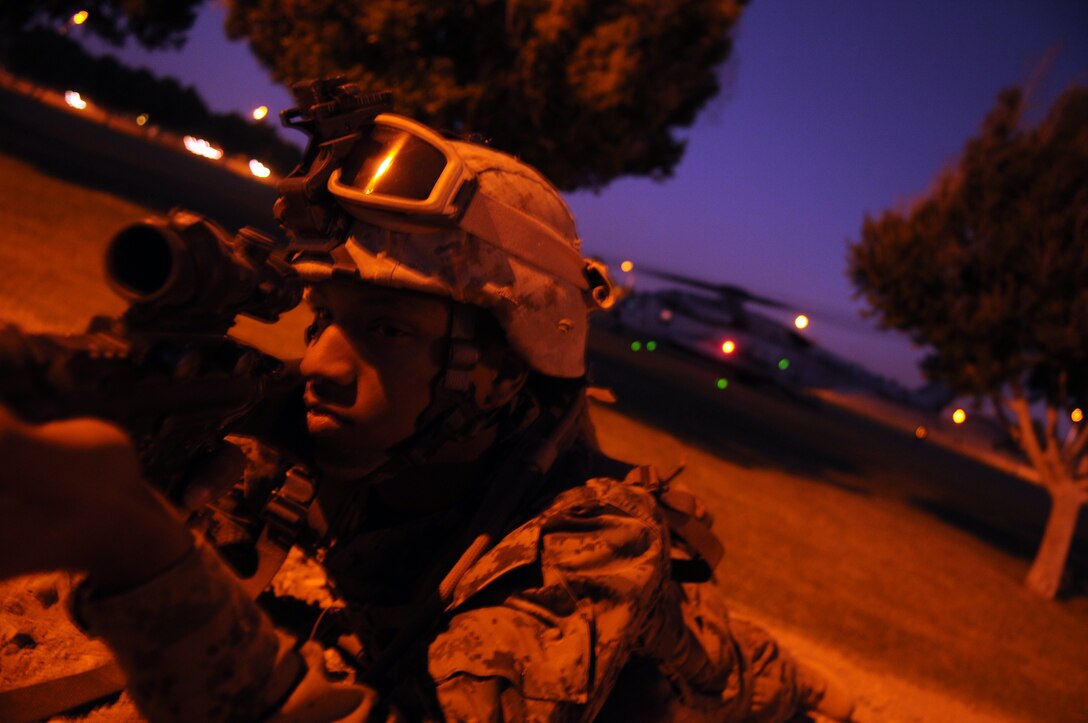 Lance Cpl. Michael Jackson, a motor transportation operator with Headquarters and Service Company, 1st Battalion, 2nd Marine Regiment, watches the perimeter of Kiwanis Park in Yuma, Ariz., as a CH-53E Super Stallion awaits evacuees to board during a noncombatant evacuation operation Oct. 23, 2009. The exercise is part of the Weapons and Tactics Instructors course and takes place in the city of Yuma to provide Marines a realistic urban setting. WTI is hosted biannually at the Marine Corps Air Station in Yuma, Ariz. The Camp Lejeune-based battalion participated in the exercise in preparation for their deployment to Afghanistan early next year. Jackson, 19, is a Baltimore native.(Photo by Cpl. Pete Zrioka)