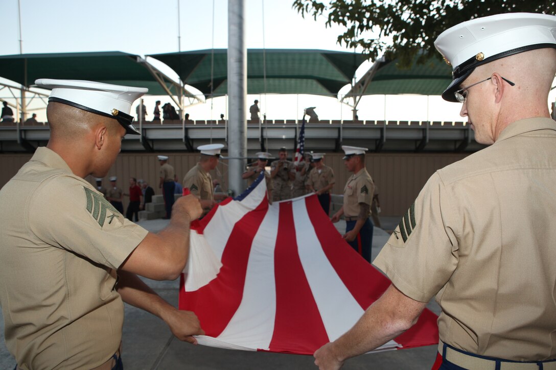 Combat Center Marines fold the American flag during evening colors Sept. 24 following the Marine Air Ground Task Force Training Command and Combat Center commanding general change of command ceremony at Lance Cpl. Torrey L. Gray Field.