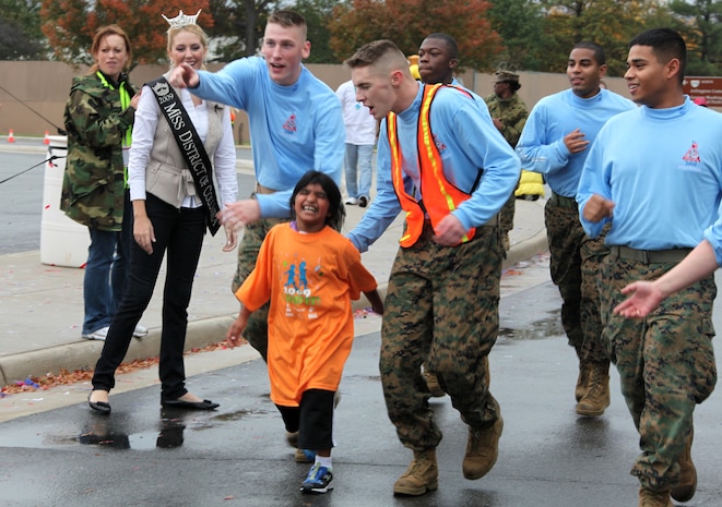 Marines who volunteered at the Healthy Kids Fun Run cheer on Sara Stachkunas, 6, as she completes the final stretch of the Healthy Kids Fun Run in Arlington, Va., Oct. 24.