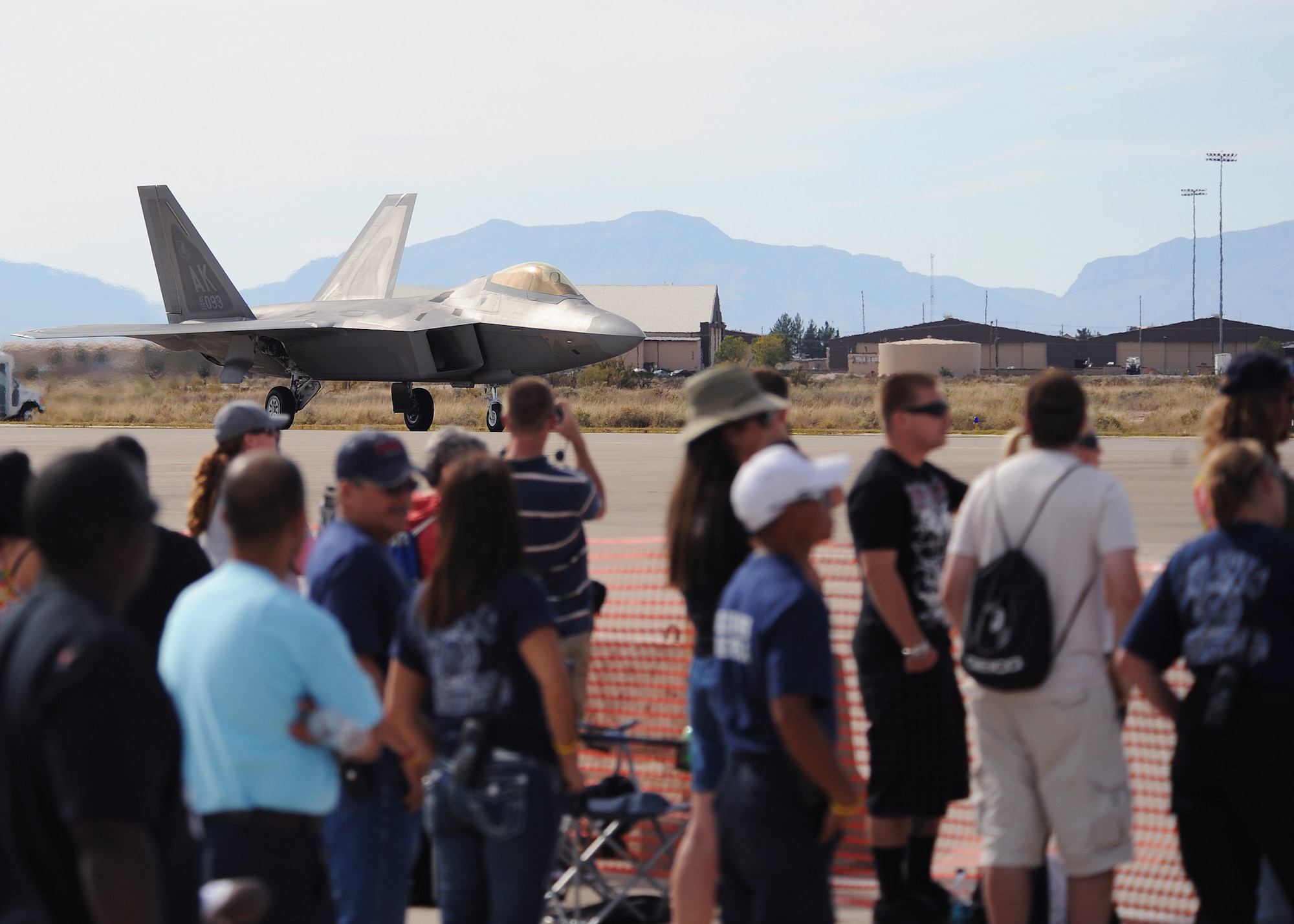 HOLLOMAN AIR FORCE BASE, N.M. -- Patrons of the 2009 open house look on as the F-22A Raptor taxis after completing it?s aerial demonstration here, Oct. 24.  While aerial acts were performed, patrons were able to buy food, drinks, squadron memorabilia and souvenirs. Children were able to enjoy the Kid?s Zone complete with bouncing castles, face painting and the chance to meet a pilot (U.S. Air Force photo by Senior Airman John D. Strong II) 