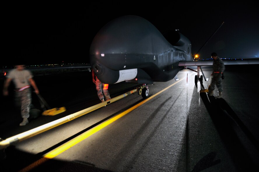 SOUTHWEST ASIA -Airmen of the 380th Expeditionary Aircraft Maintenance Squadron attach a tow bar to an RQ-4 Global Hawk Oct. 22, 2009. The Global Hawk aircraft is a high-altitude, long-endurance, unmanned aircraft system that provides intelligence, surveillance and reconnaissance. (U.S. Air Force photo/Tech. Sgt. Charles Larkin Sr)