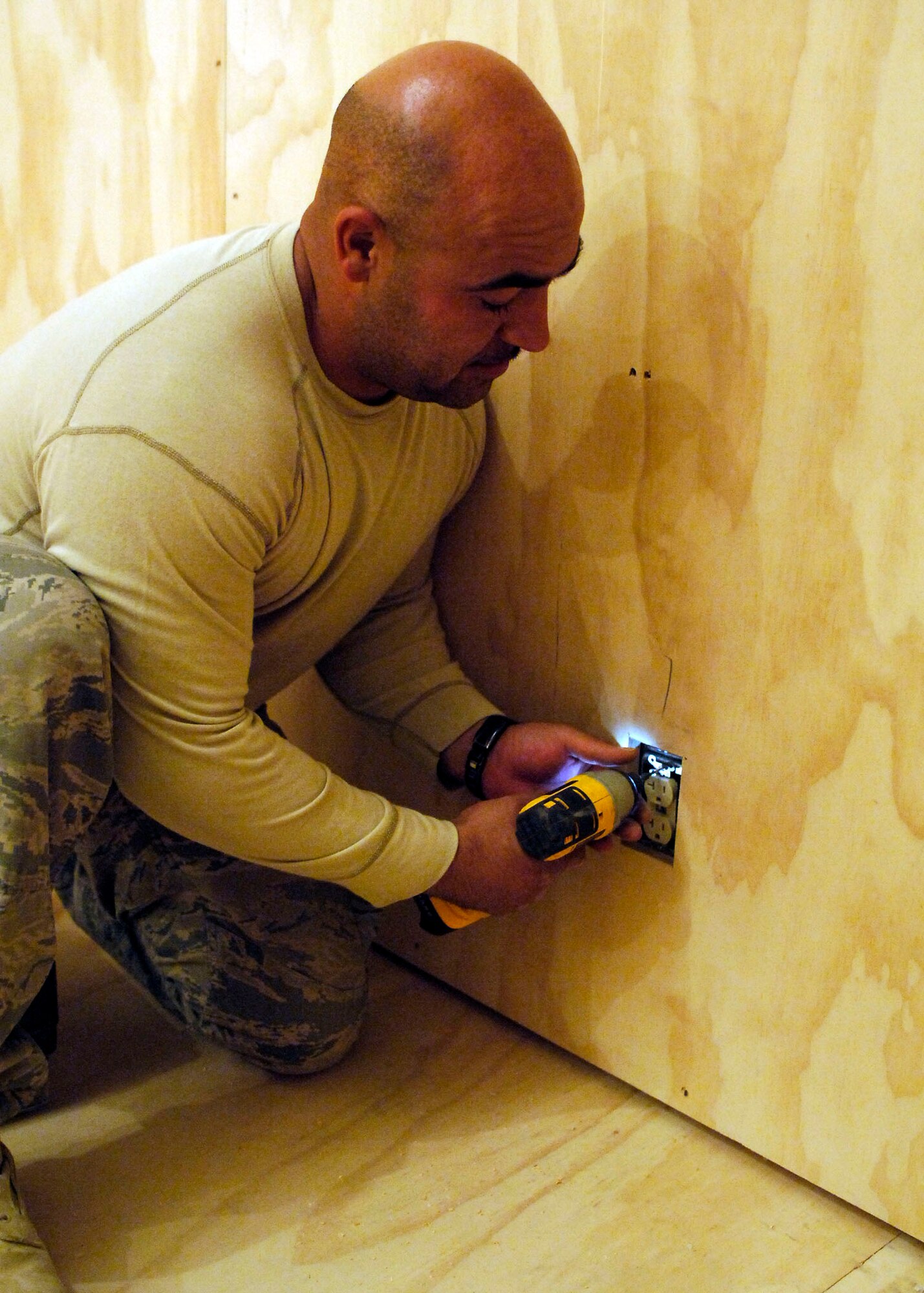 BAGRAM AIRFIELD, Afghanistan -- Staff Sgt. Efrain Roldan, an electrician from the 455th Expeditionary Civil Engineer Squadron, unscrews an electrical outlet to add spacers, Oct. 24, 2009.  The spacers must be added to allow Sergeant Roldan to attach an electrical outlet cover.  After the 455th ECES builds a new facility the electricians must lay all of the wires to provide power.  Sergeant Roldan is deployed from Vandenberg Air Force Base, Calif., and hails from Bronx, N.Y.  (U.S. Air Force photo/Senior Airman Felicia Juenke)