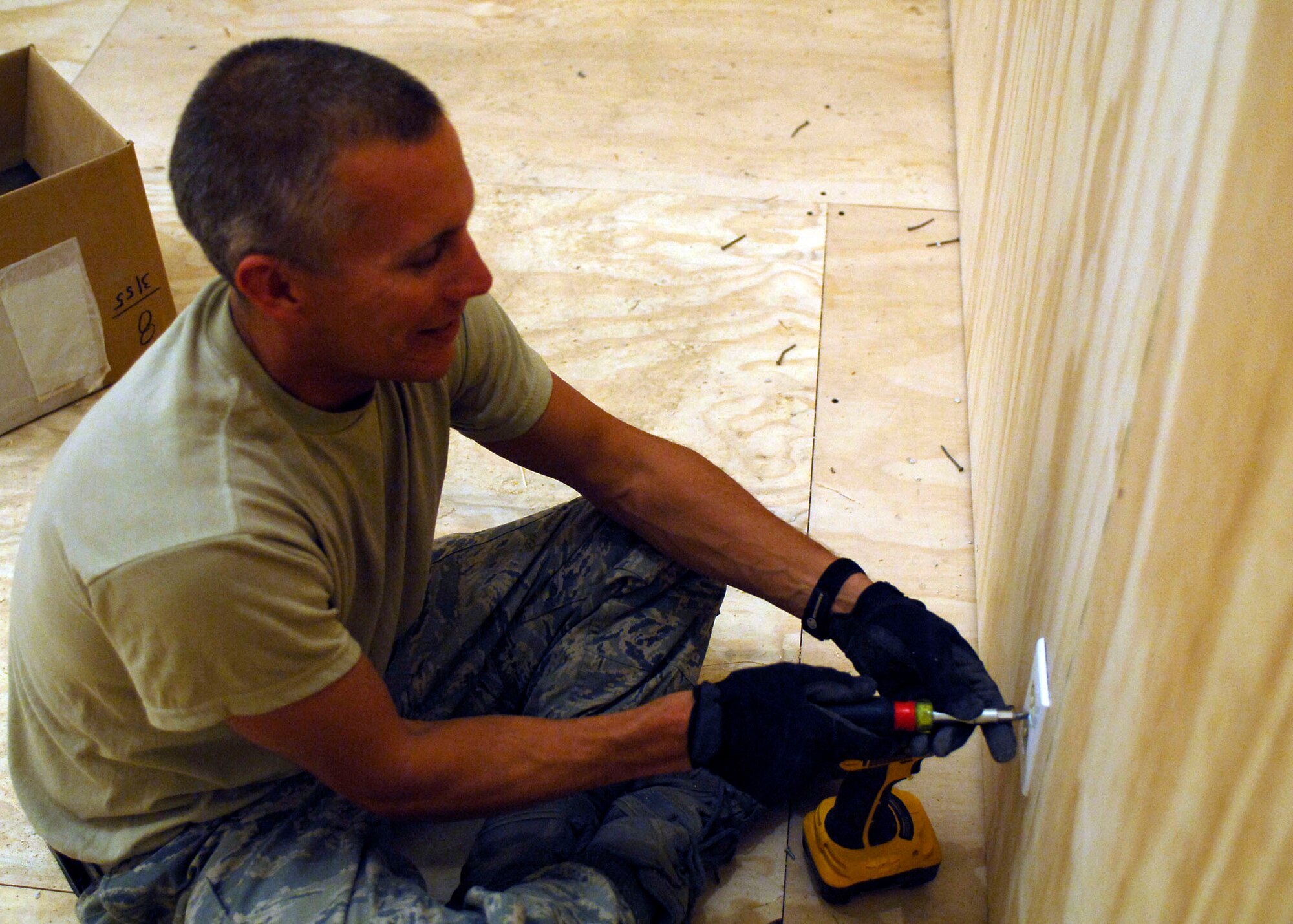 BAGRAM AIRFIELD, Afghanistan -- Tech. Sgt. Sean O'Brien, an electrician from the 455th Expeditionary Civil Engineer Squadron, attaches an electrical outlet cover, Oct. 24, 2009.  After the 455th ECES builds a new facility the electricians must lay all of the wires to provide power.  Sergeant O'Brien is deployed from the Nevada Air National Guard's 152nd CES and hails from Reno, Nev.  (U.S. Air Force photo/Senior Airman Felicia Juenke)